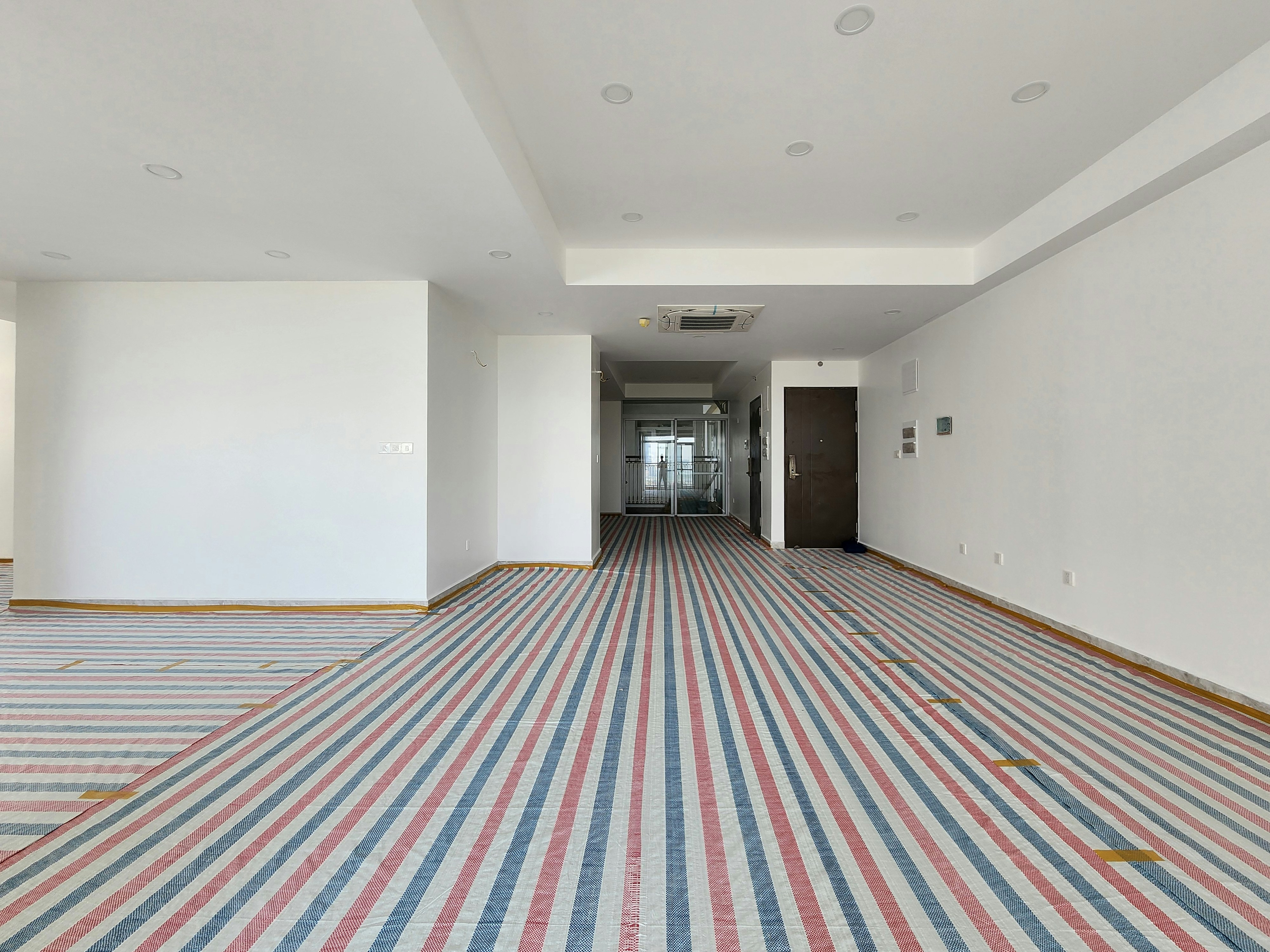 An empty room with striped carpet and white walls.