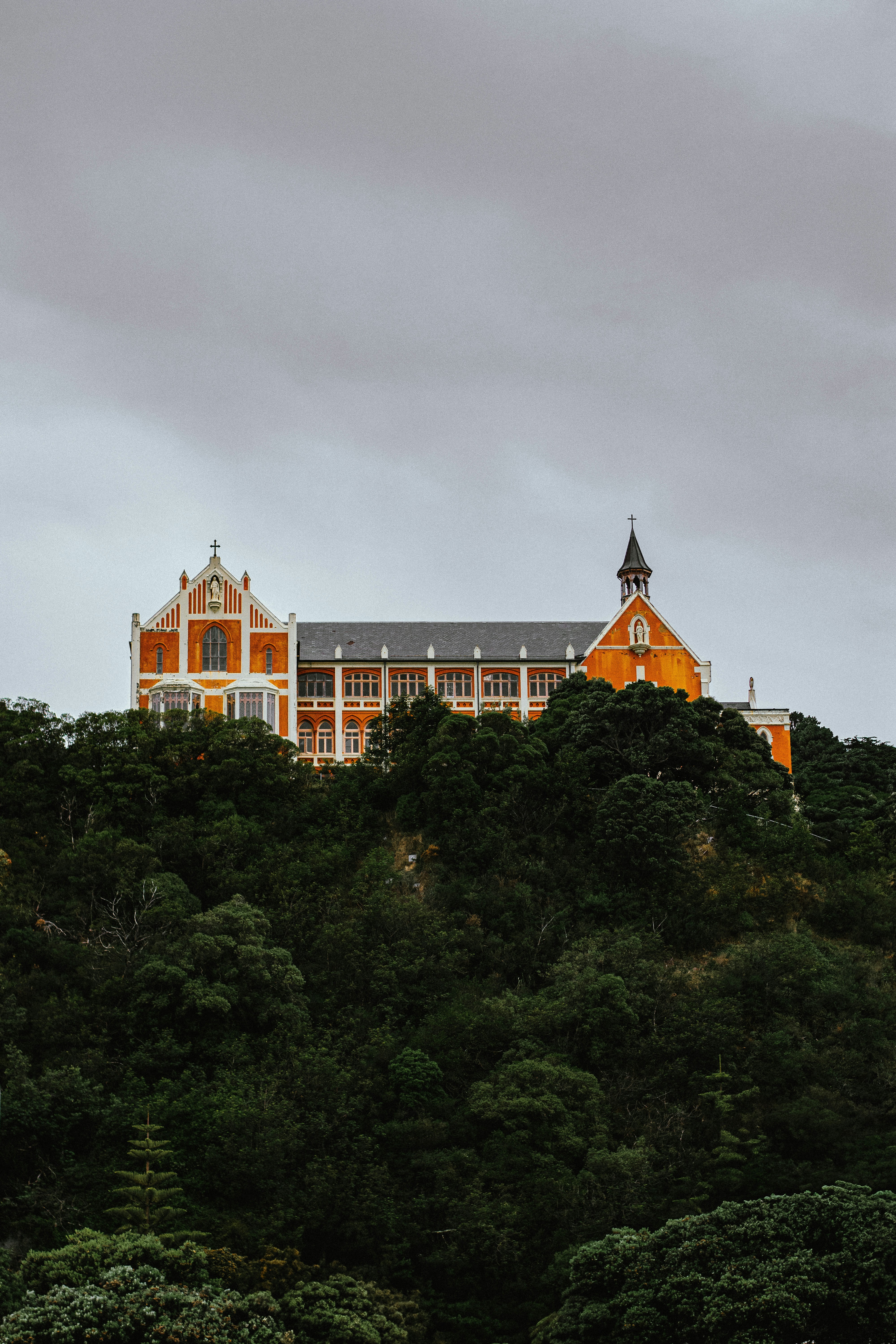 Das orangefarbene Gebäude steht auf einem üppig grünen Hügel.