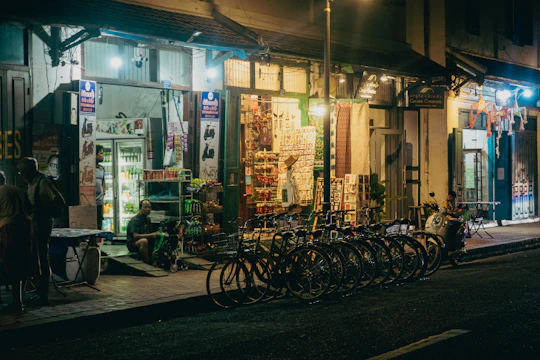Shops are lit up on a dark, quiet street.