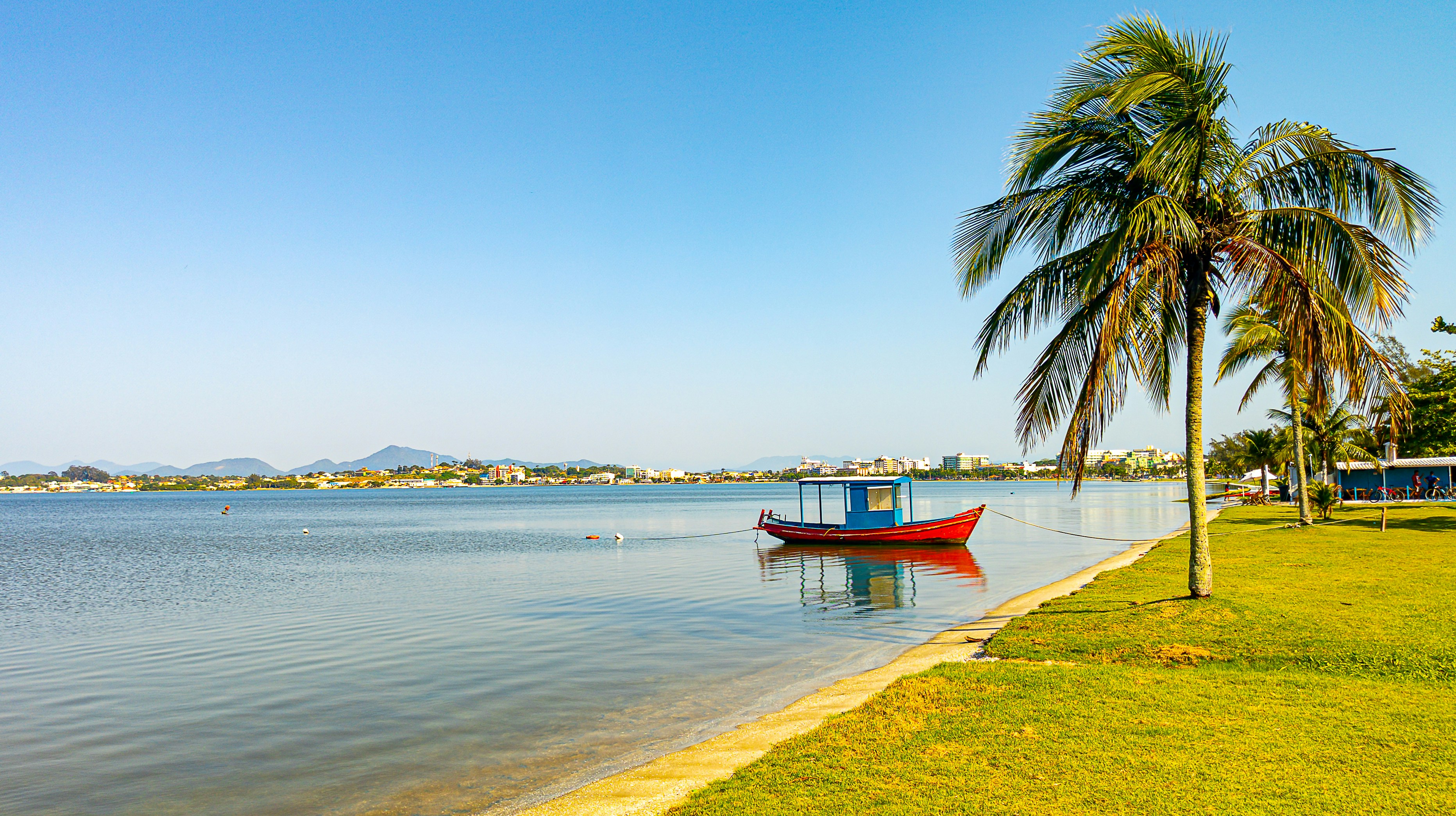 A boat floats peacefully in the blue water.
