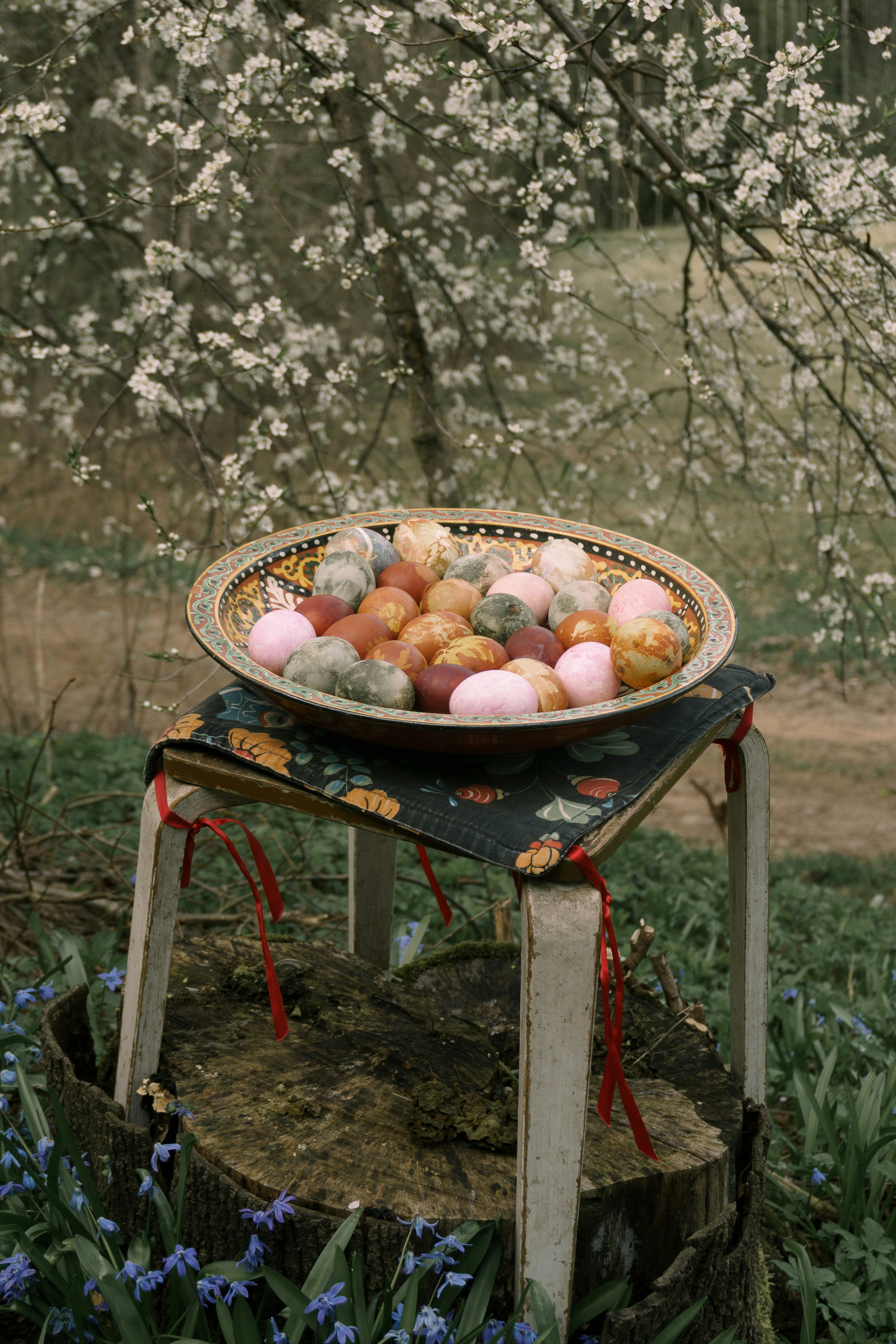 カラフルなイースターエッグが屋外のスツールに展示されています。