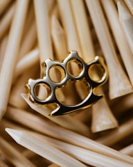 Golden knuckle duster rests on wooden toothpicks.