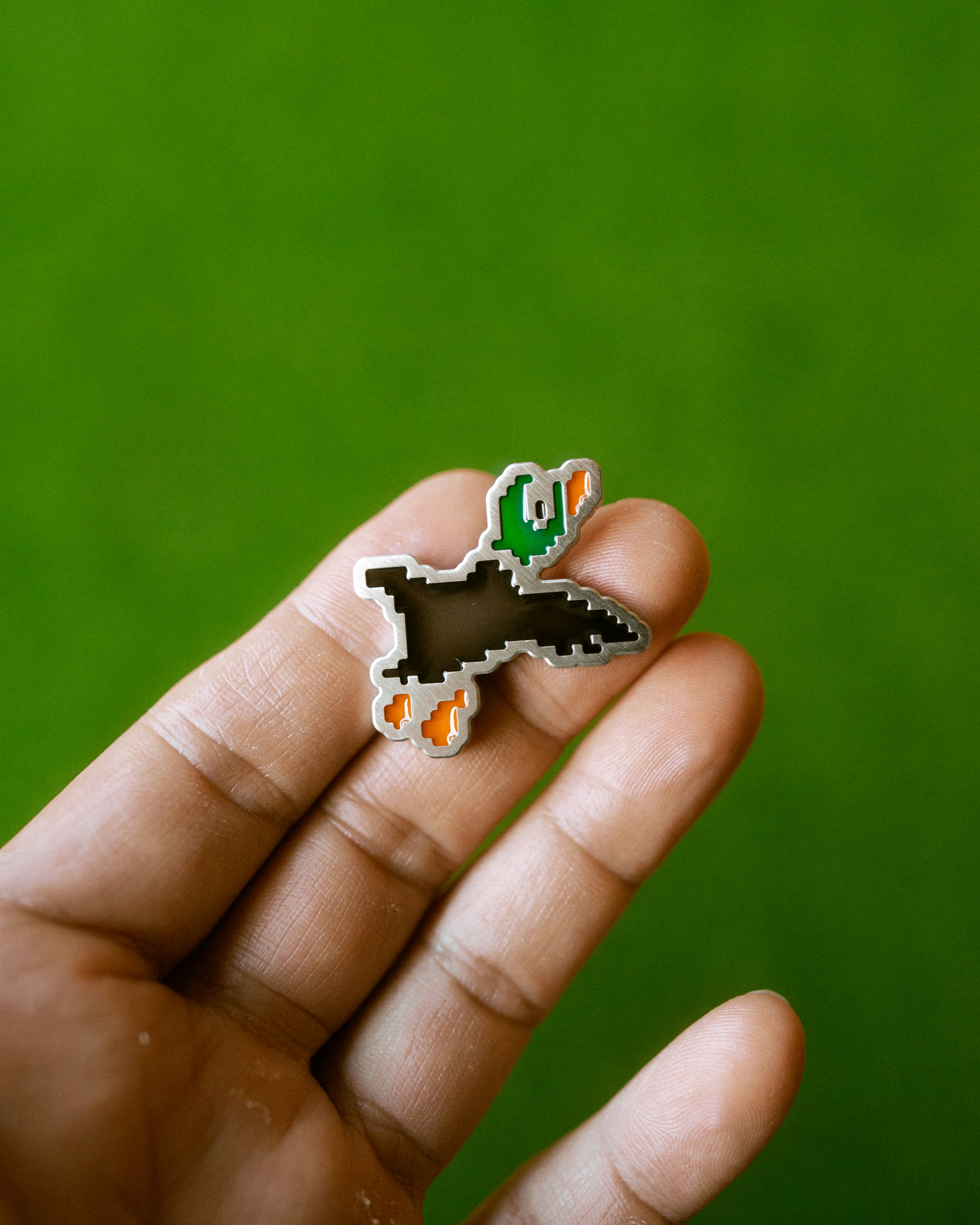 A pixelated duck hunt duck pin.