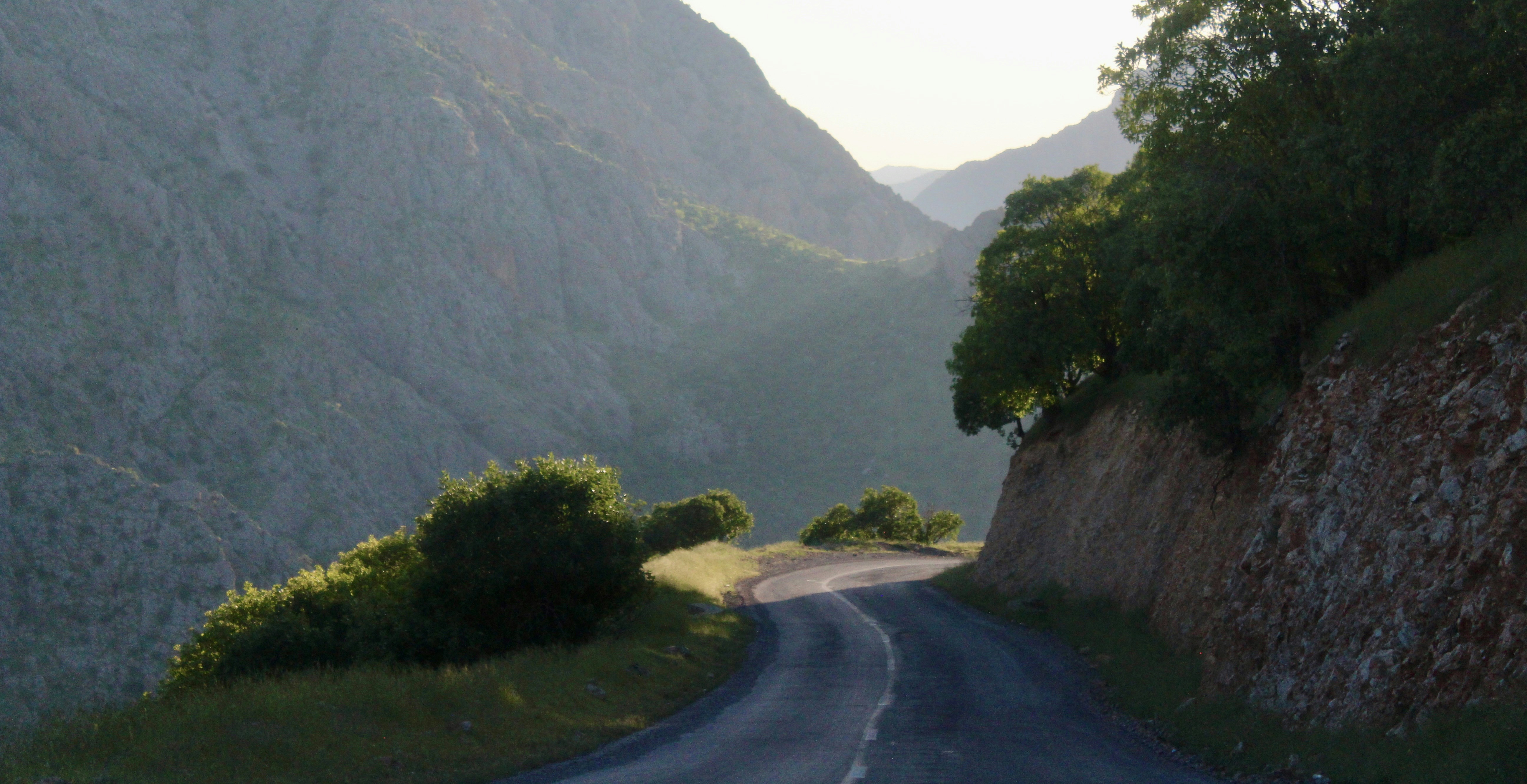 A winding road travels through mountain scenery.
