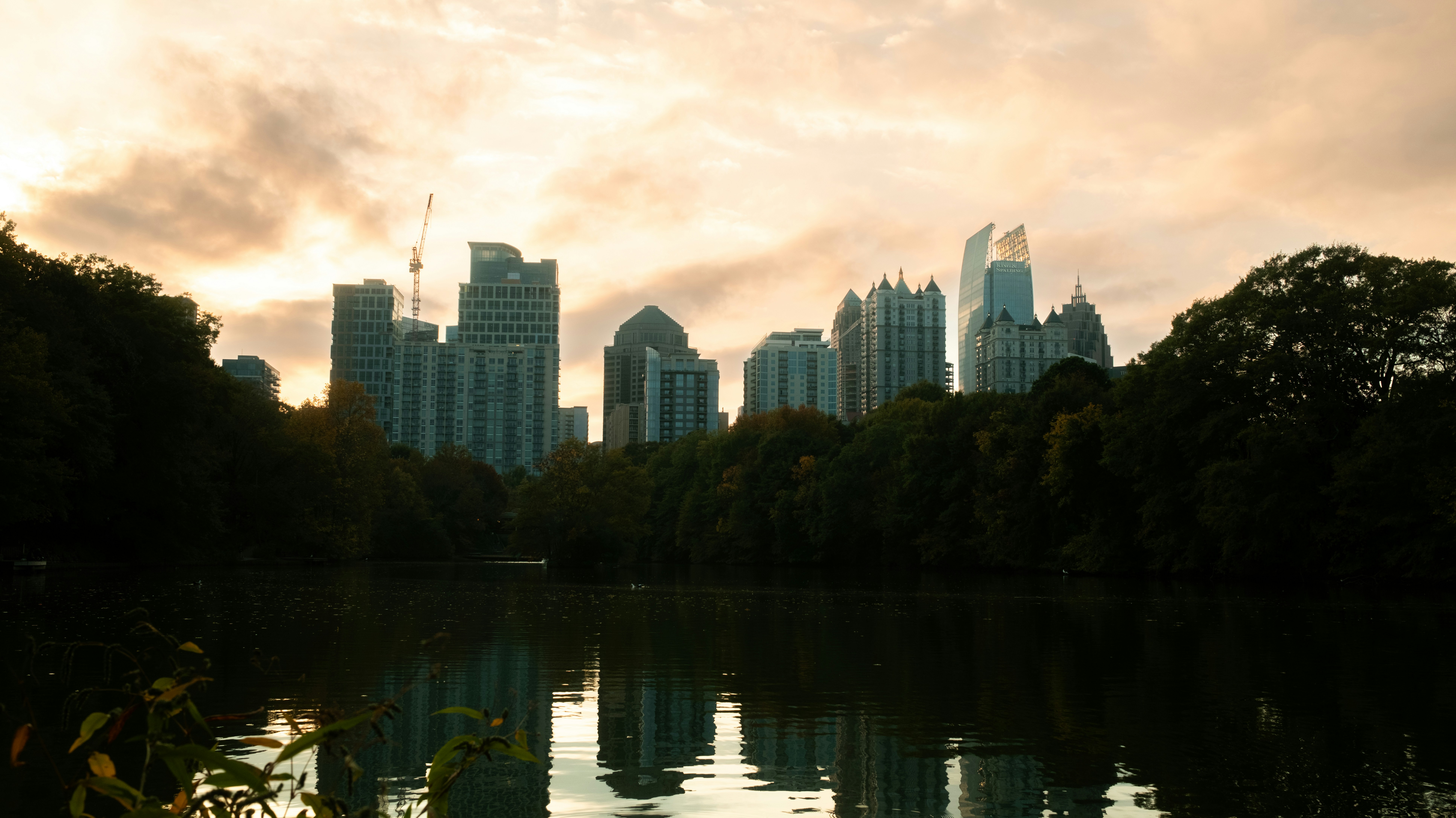 City skyline reflected on a lake at dusk.
