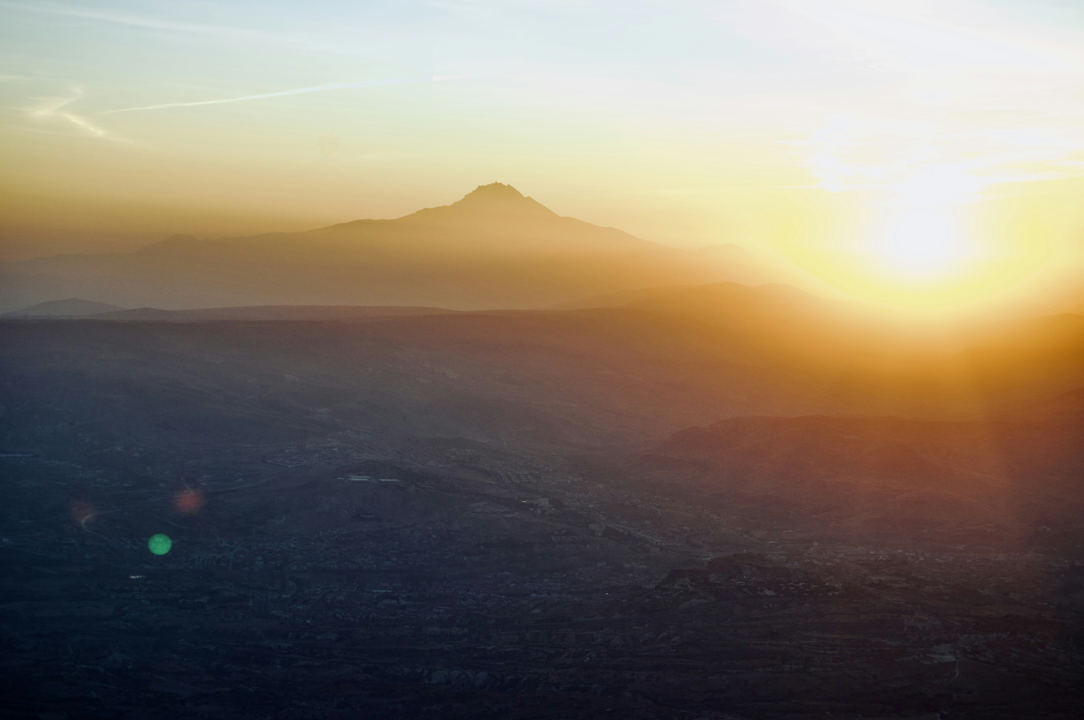 Puesta de sol sobre un paisaje montañoso brumoso.
