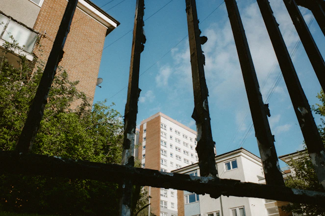 Buildings seen through a grimy metal gate
