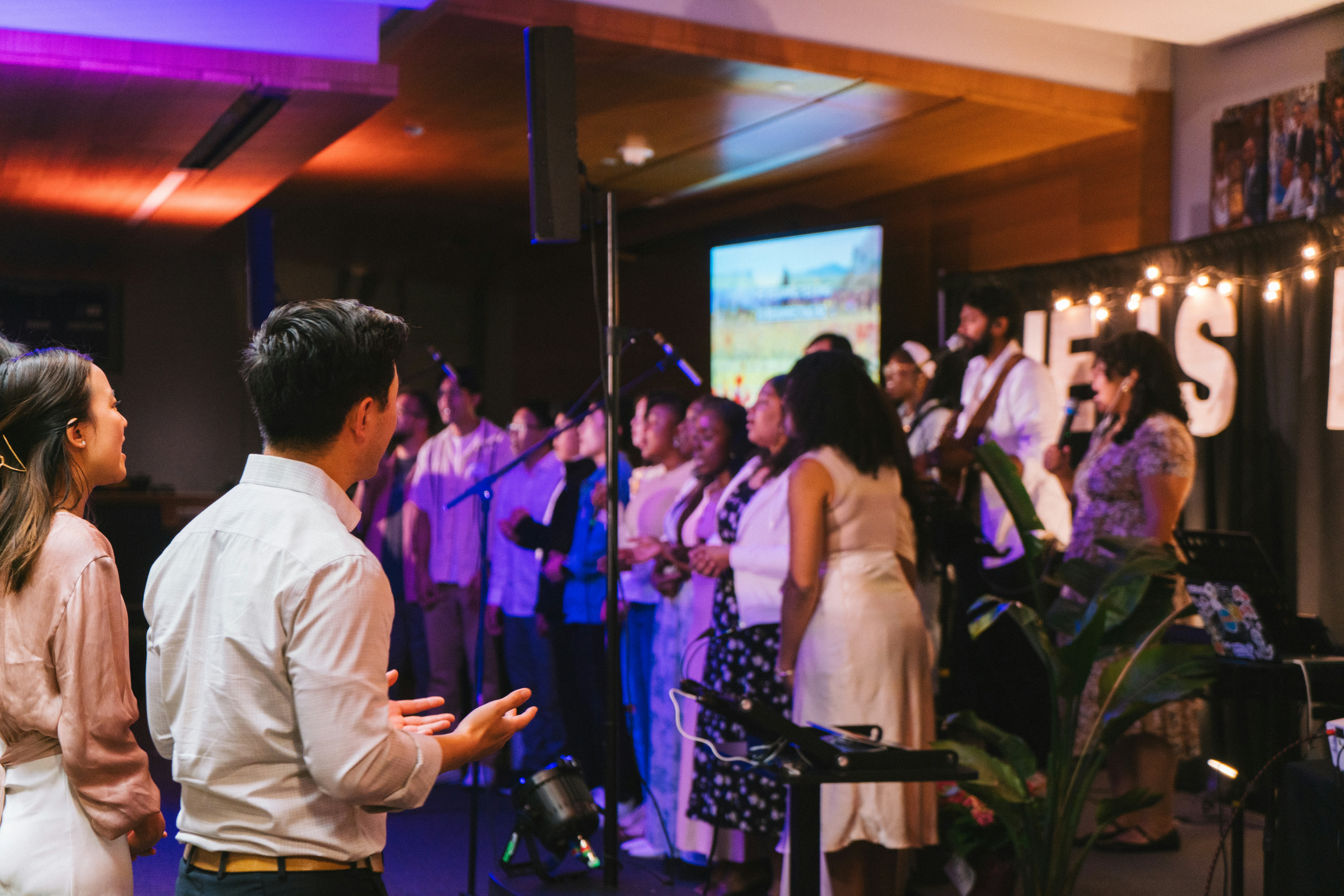 A choir performs on stage in front of an audience.