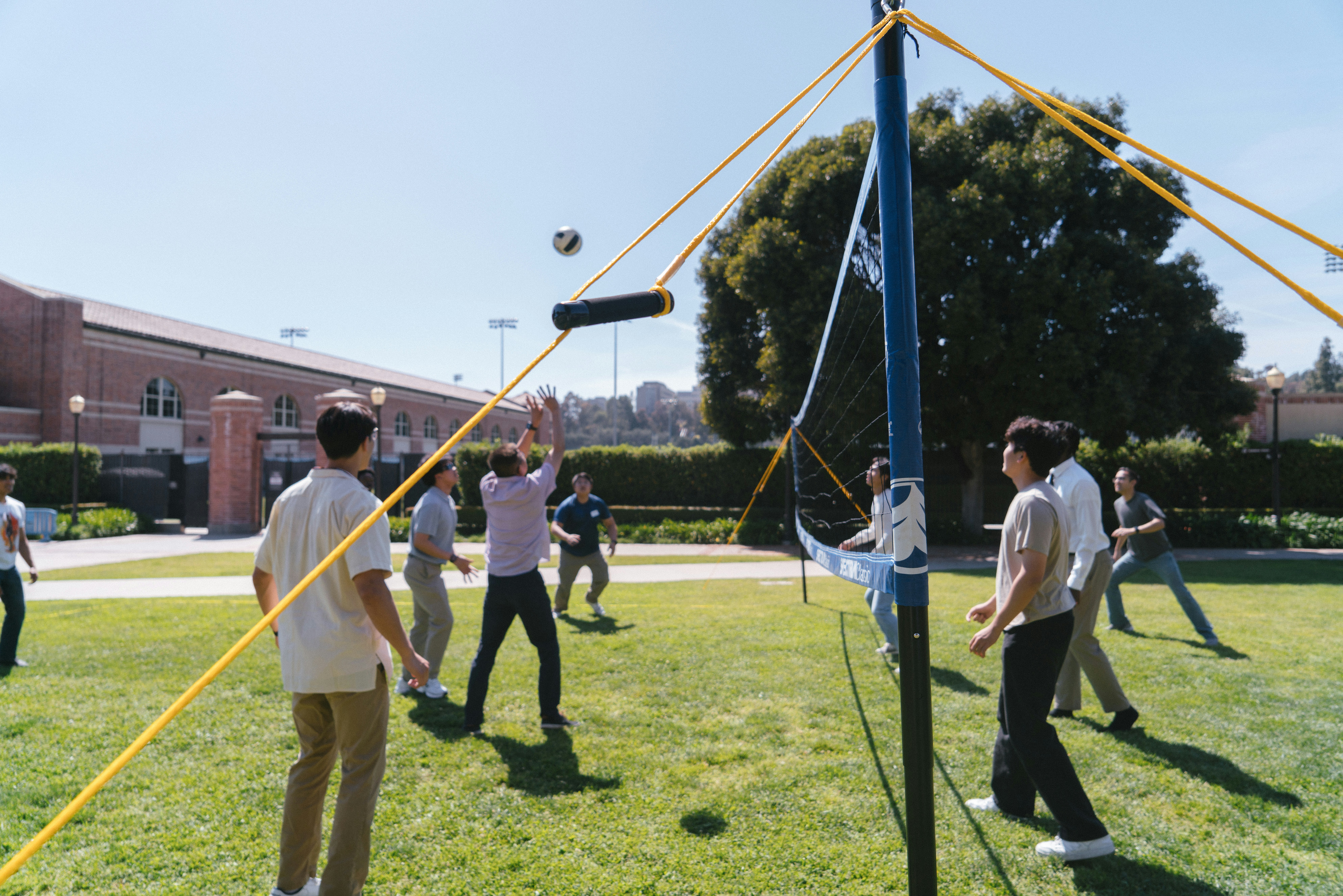 People are playing volleyball on a sunny day.