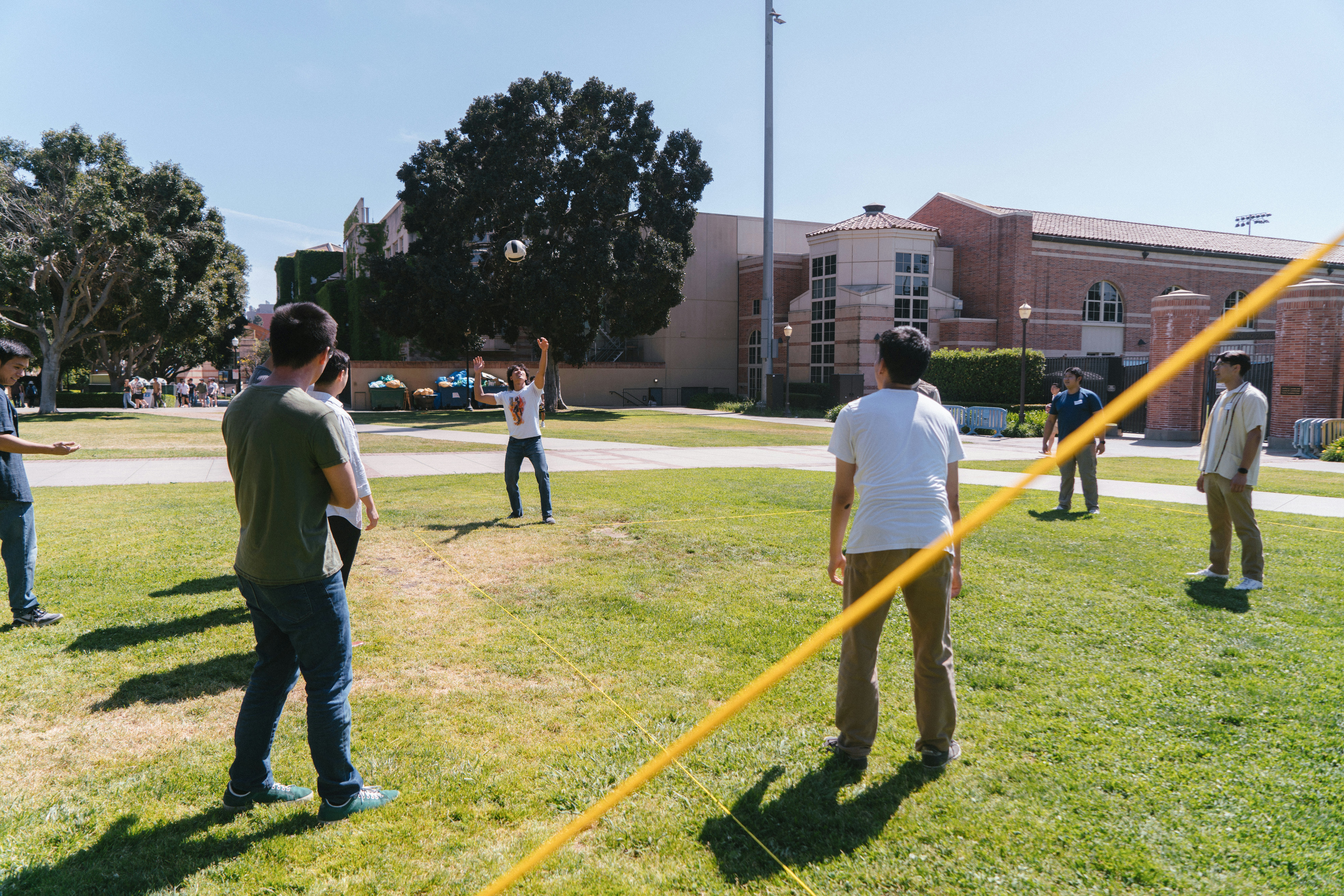 People are playing volleyball on a sunny day.