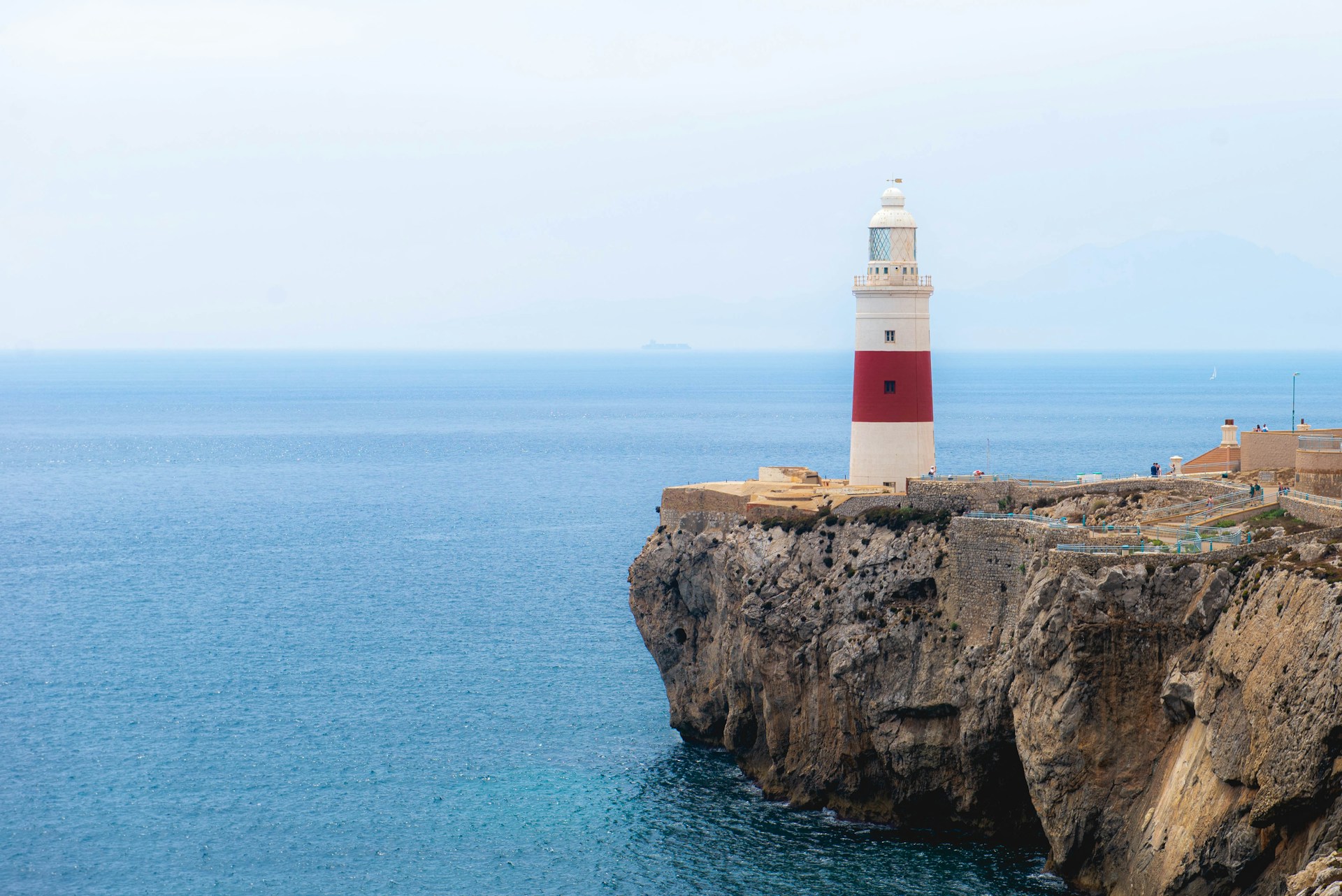 A lighthouse stands proudly overlooking the ocean.