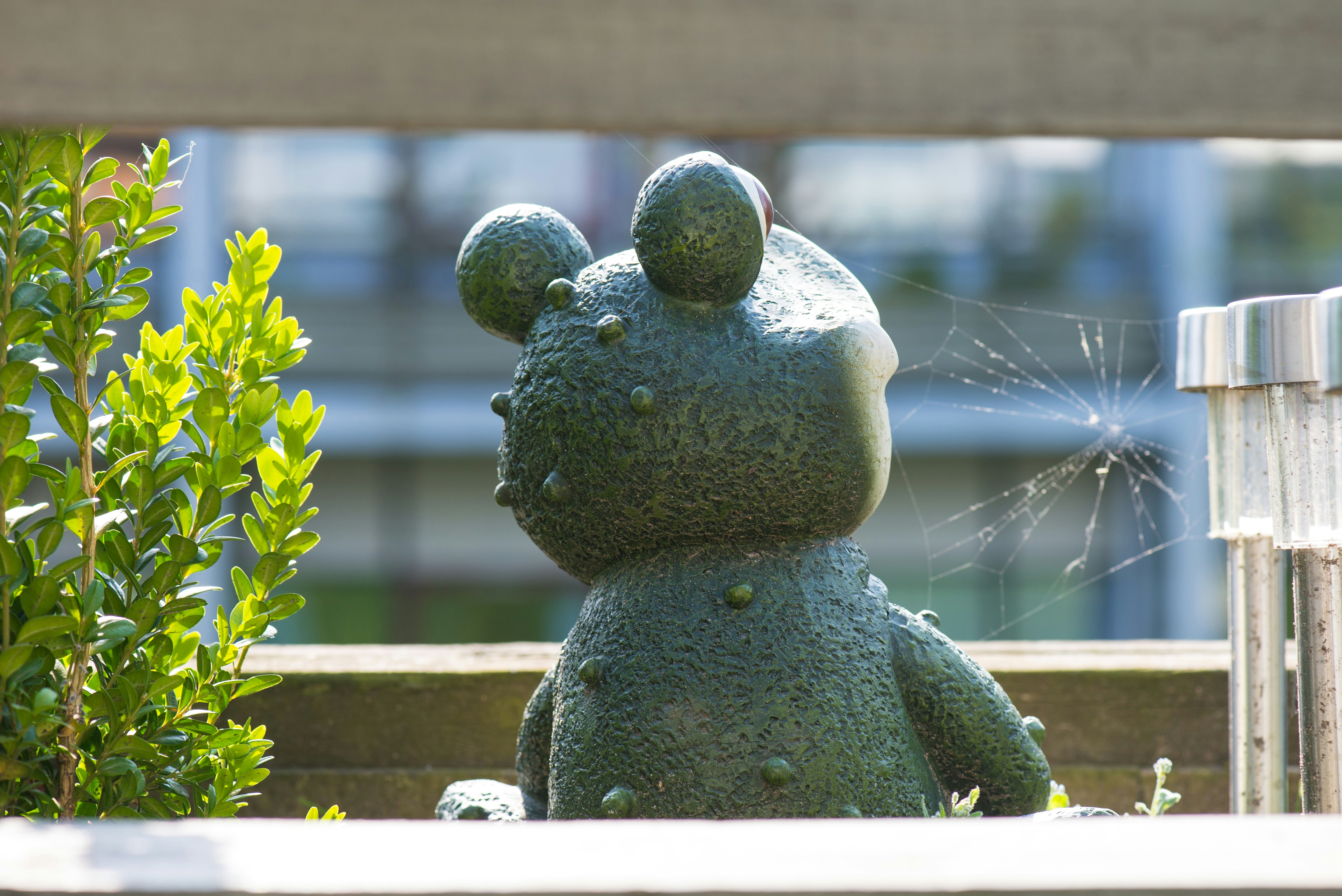 A green, bumpy garden gnome statue sits outdoors. photo – Free Image on ...