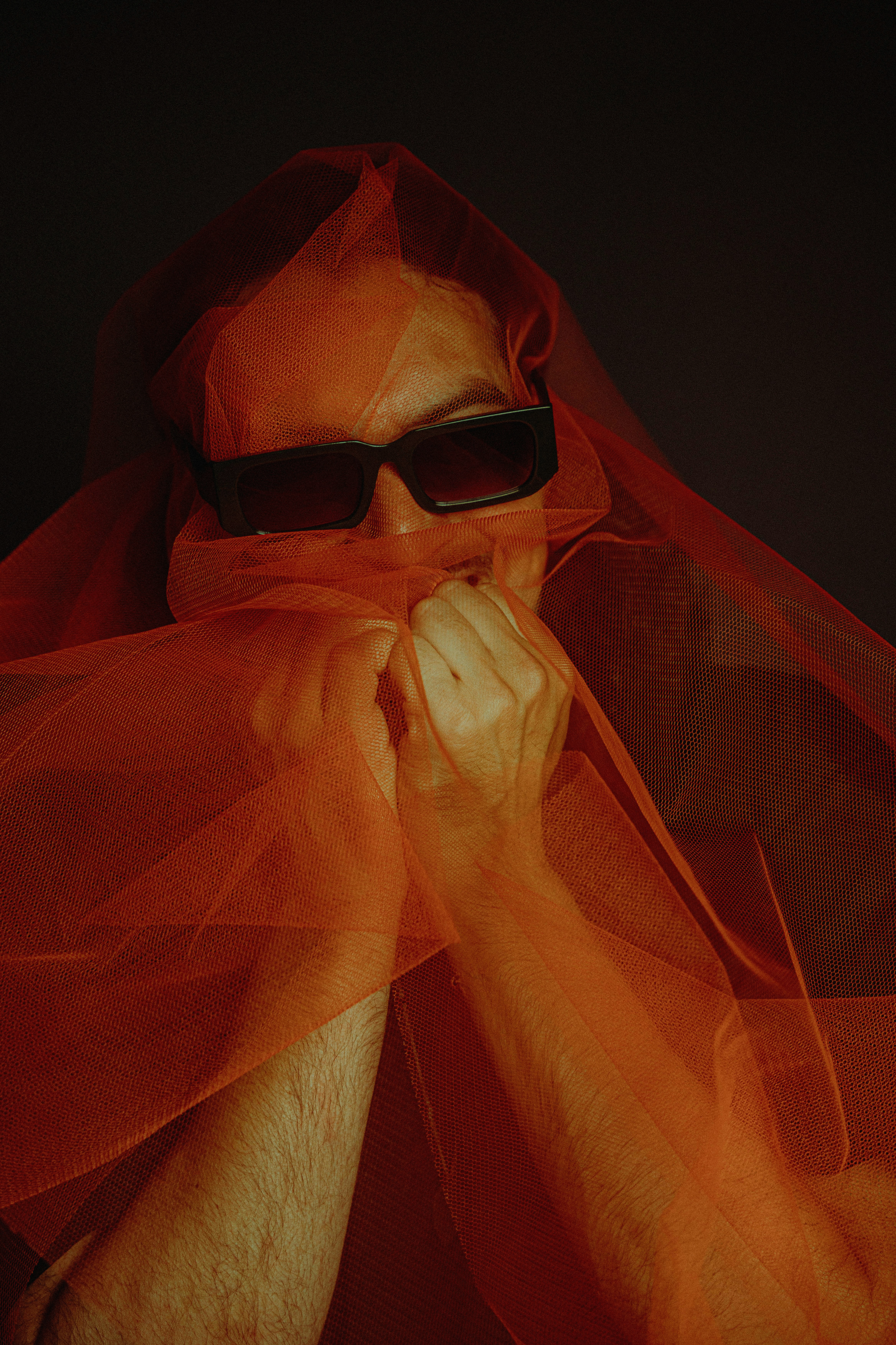 A person in sunglasses and red tulle.
