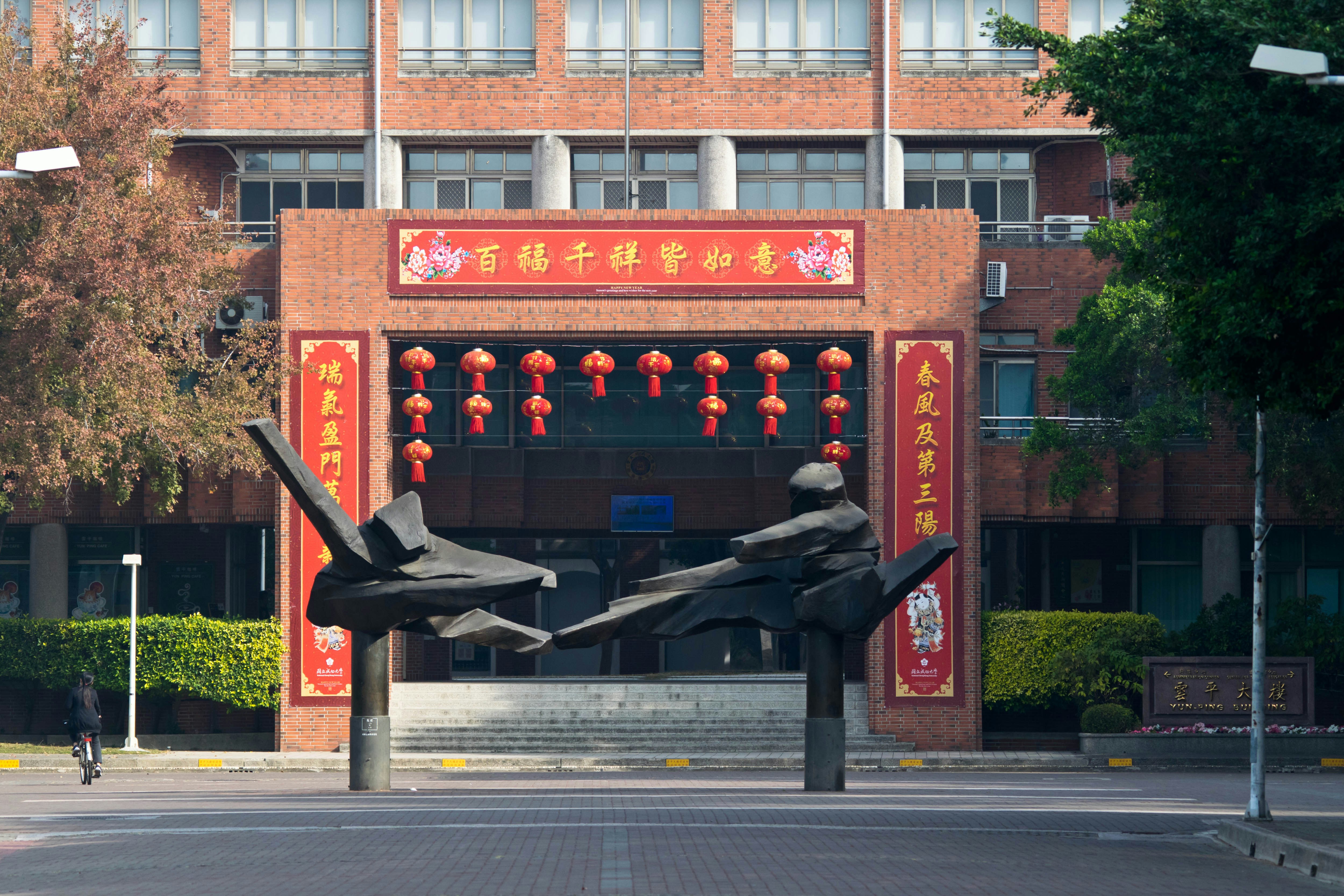 A chinese building with artwork in front.