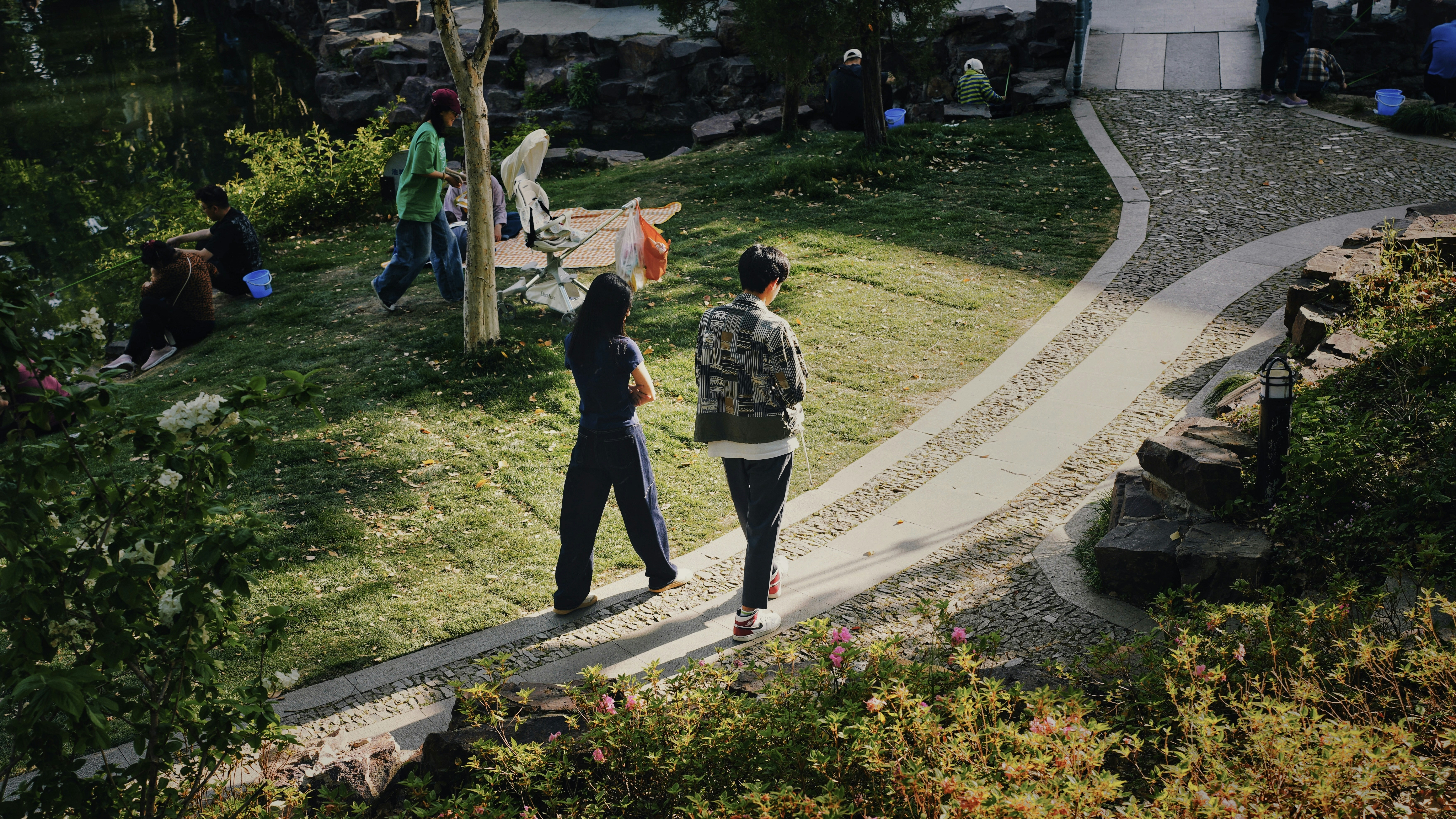 People walk on a path in a garden.