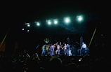 A band performs on stage for a large crowd.