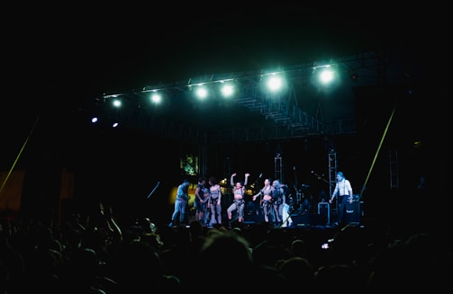 A band performs on stage for a large crowd.
