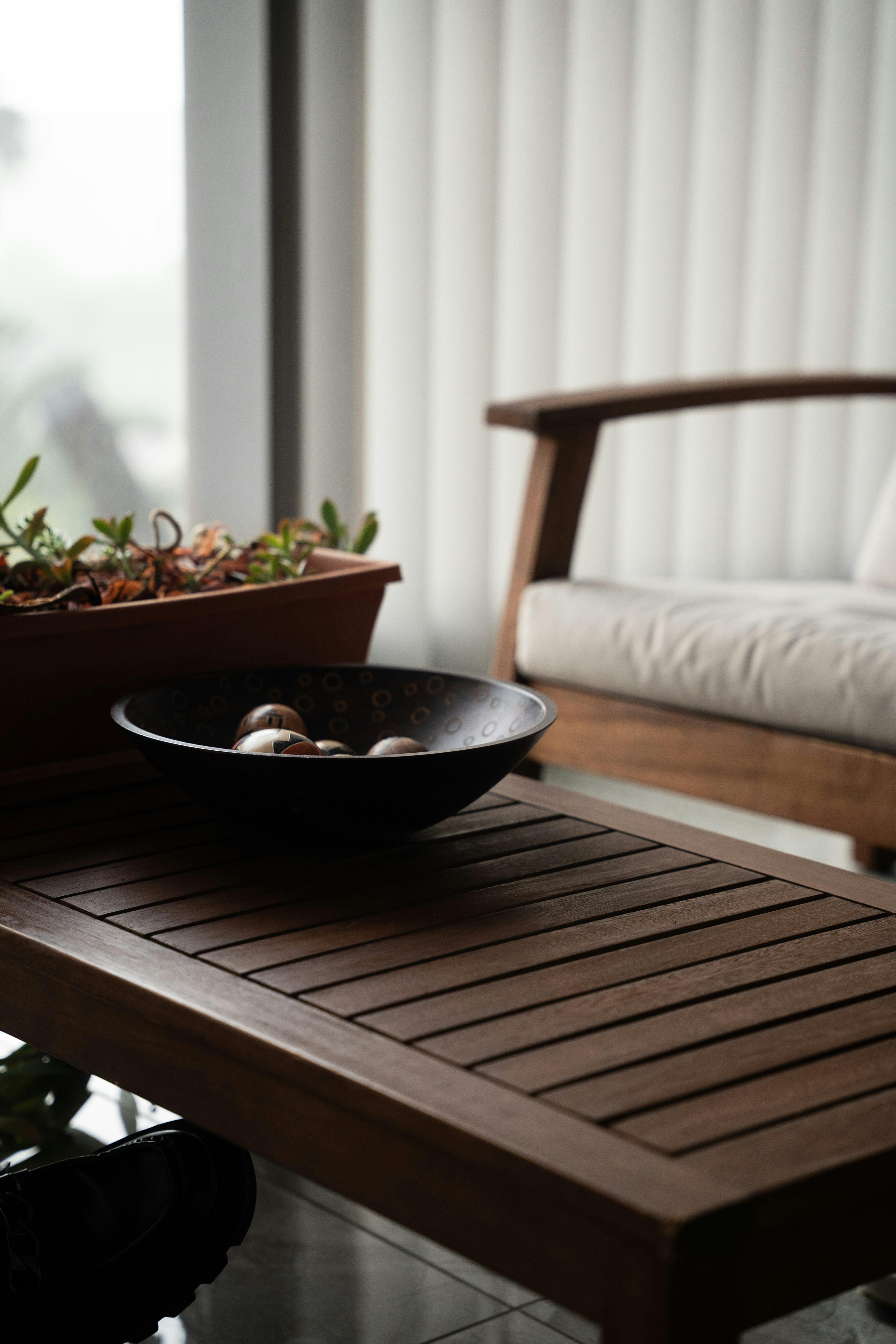 Ein Couchtisch mit einer Schüssel und einem Holzstuhl.