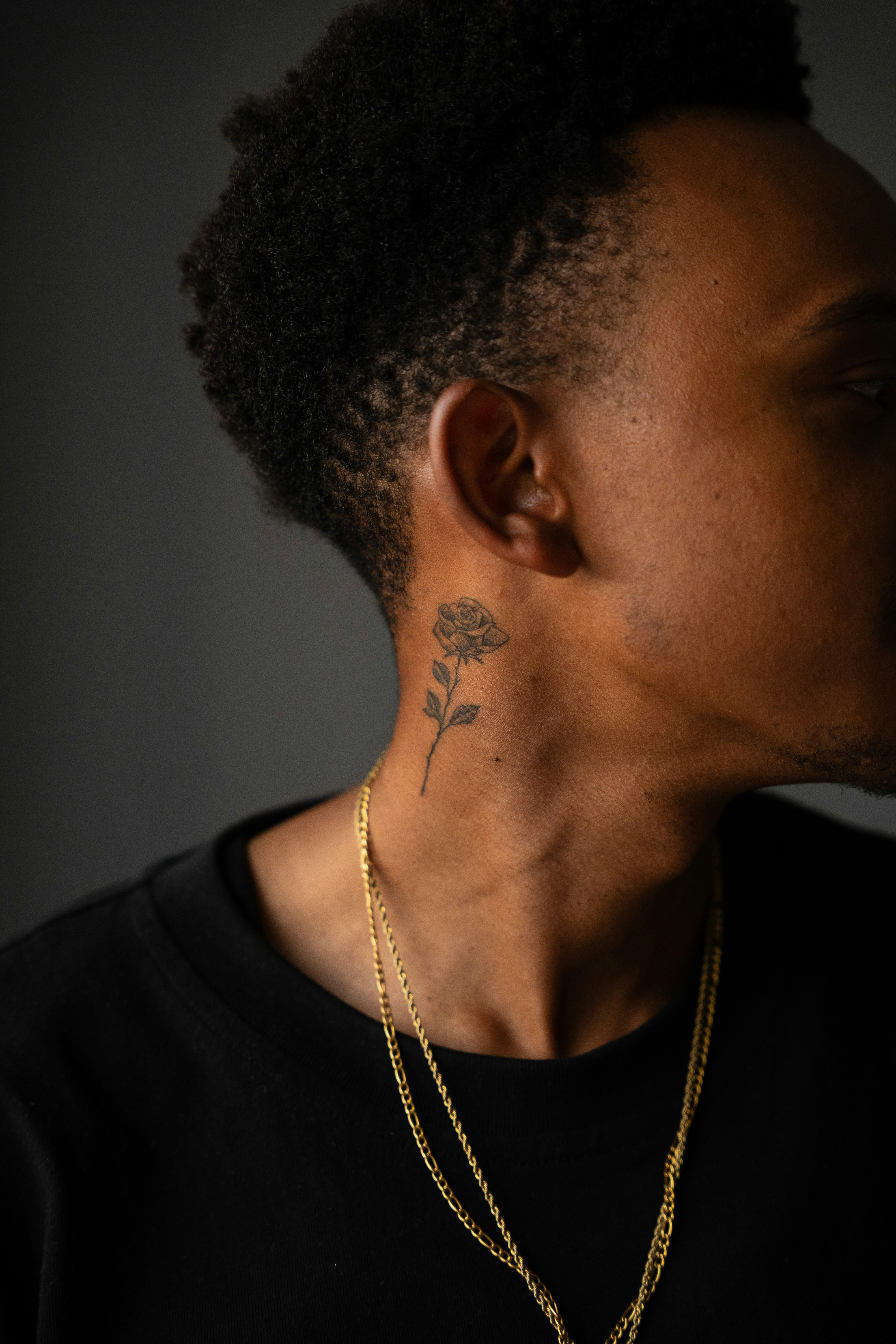 Man with a rose tattoo on his neck.