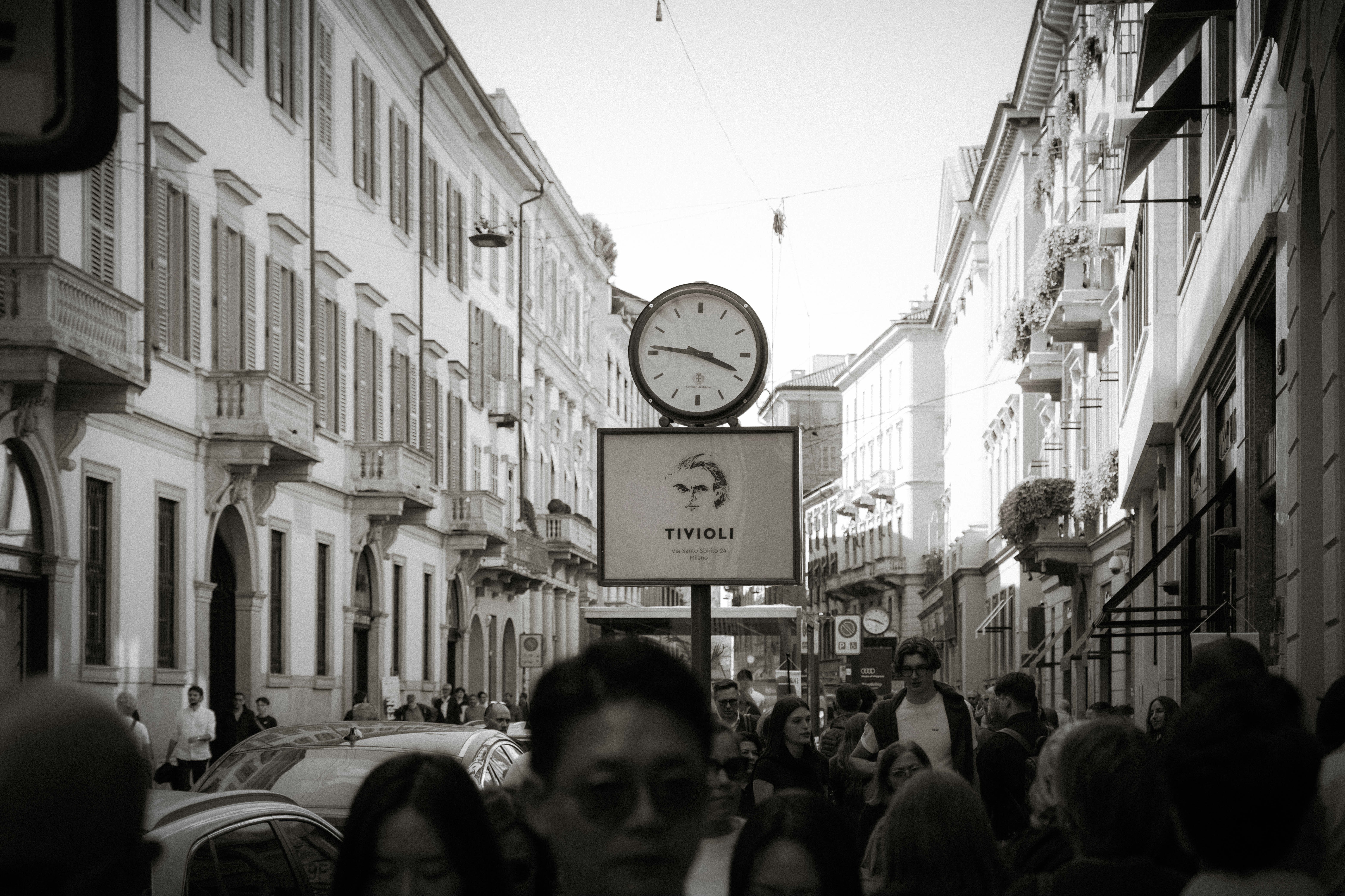 Scena di strada affollata con un grande orologio.