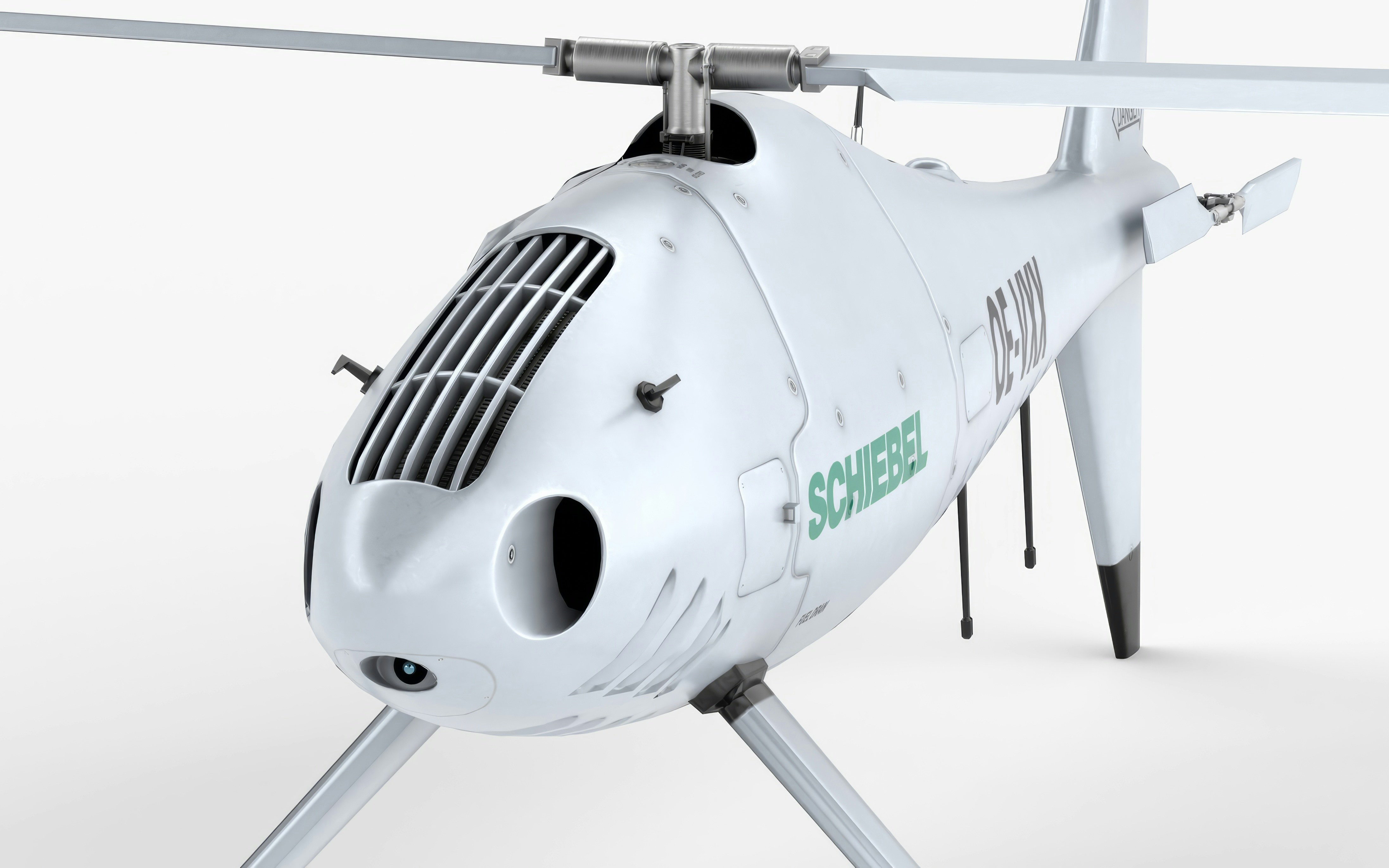 A white drone helicopter rests on the ground.