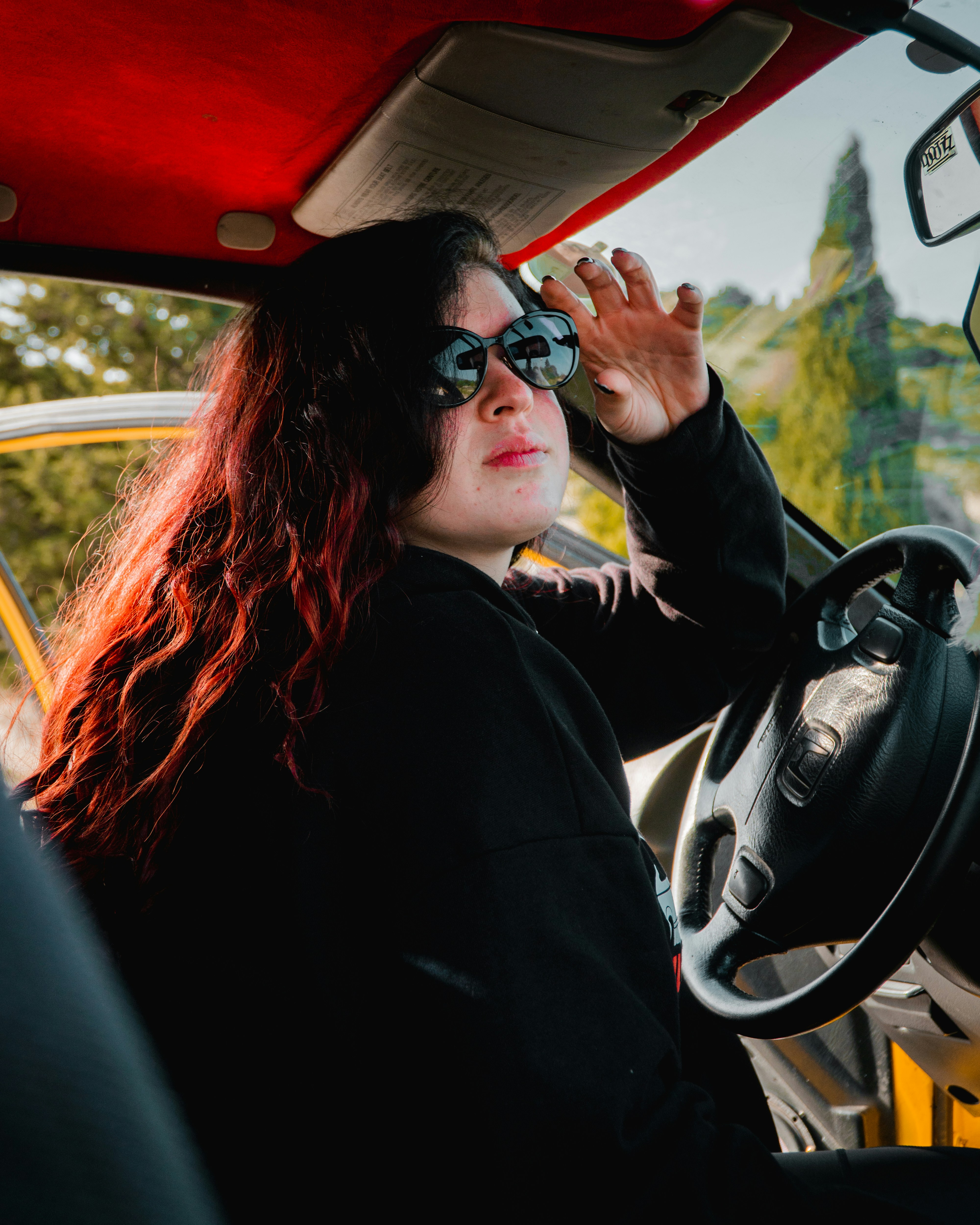 Woman in sunglasses sitting in a car.