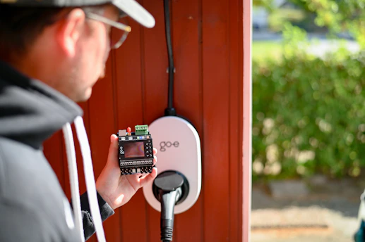 Man is examining an electric vehicle charger.