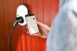 Person uses phone to control electric vehicle charger.