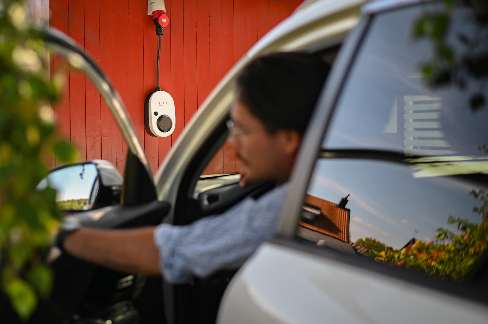 Un client Solaris Charge rejoint sa voiture électrique garée près d'une borne de recharge