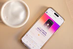 Phone displays social media news next to a coffee.