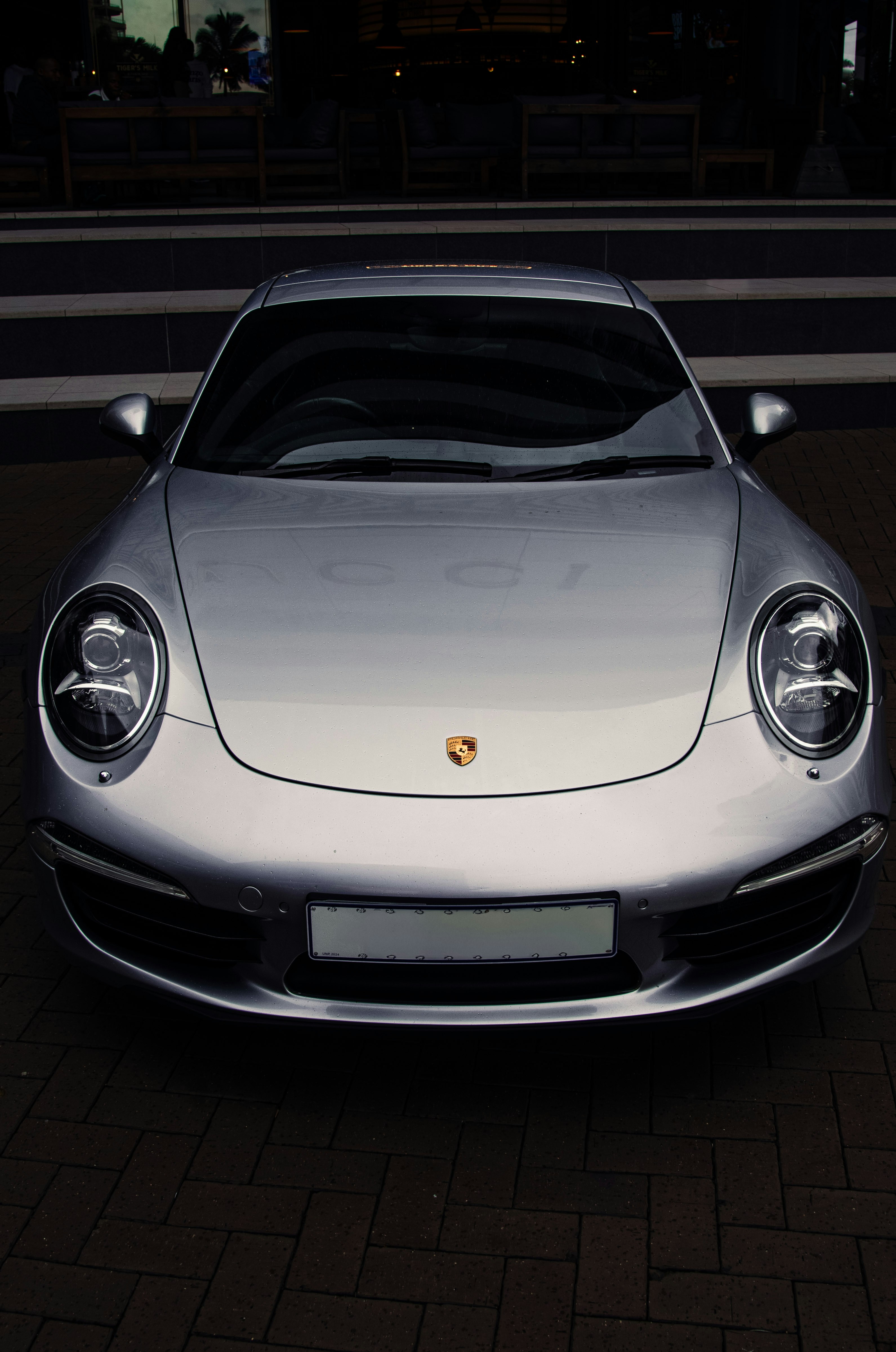 A silver porsche car parked.