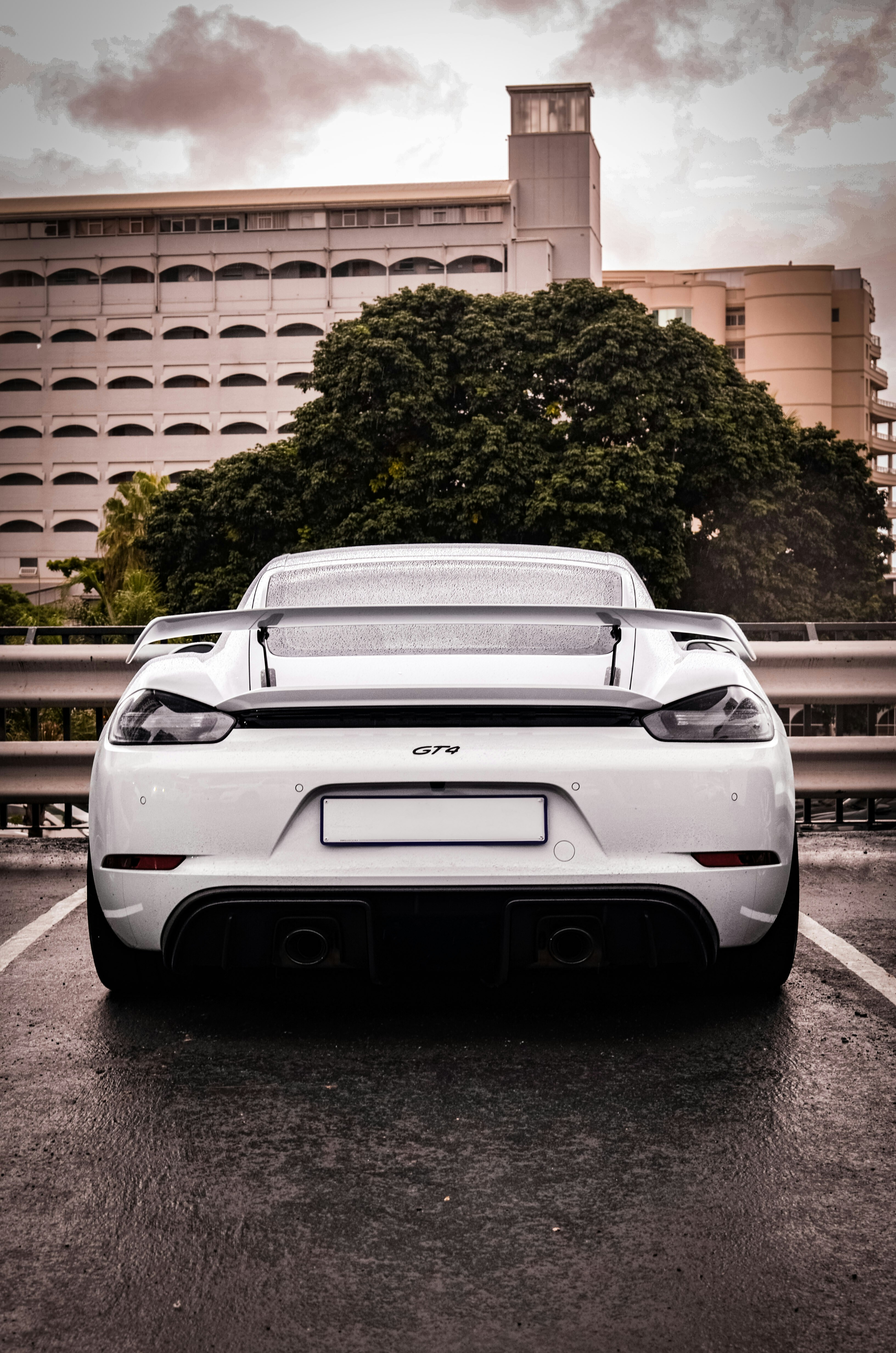 A white porsche is parked in a parking lot.