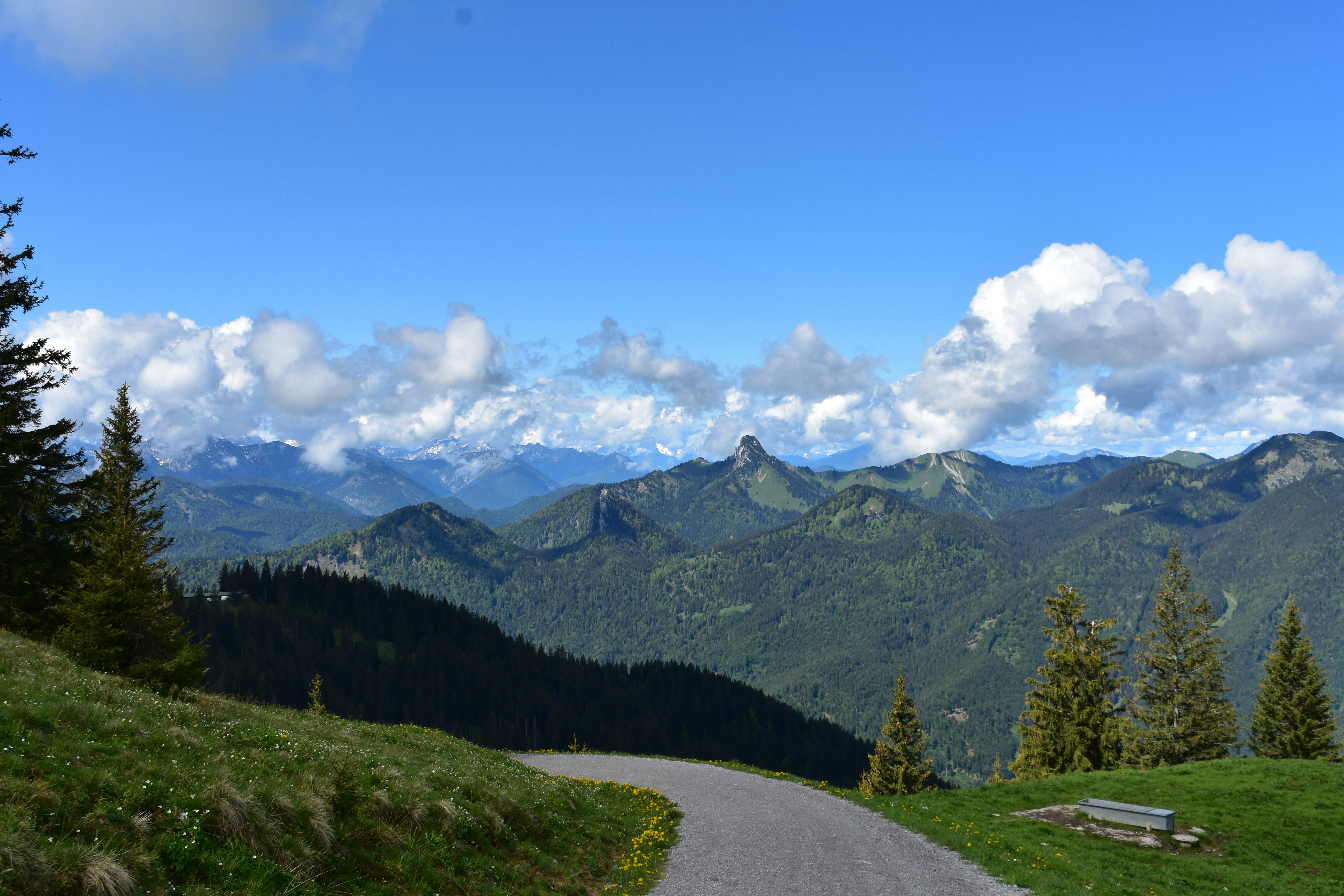 A winding road overlooks a beautiful mountain range.