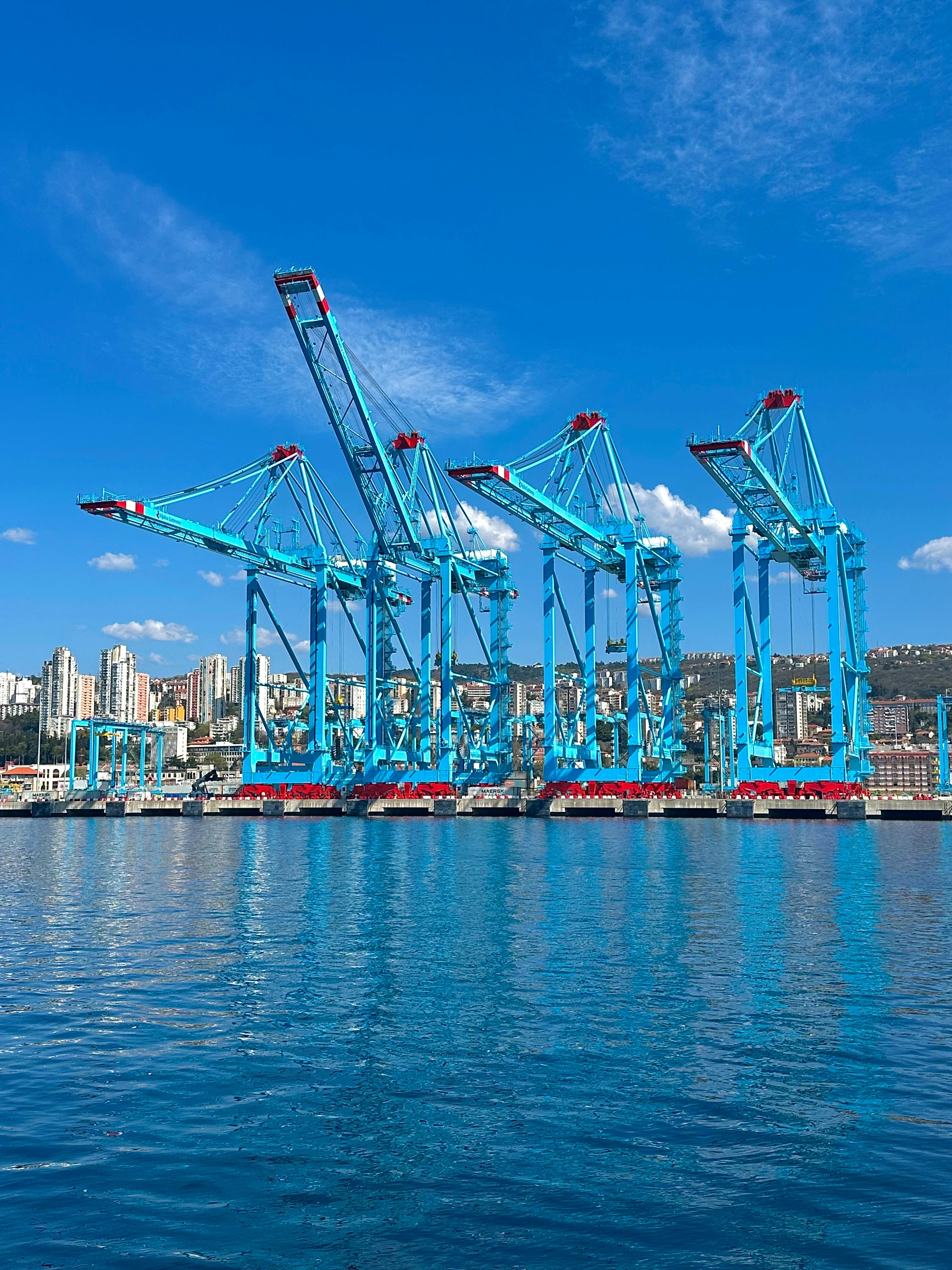 Dock cranes stand tall at a seaside port.