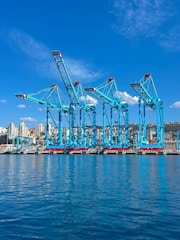 Dock cranes stand tall at a seaside port.