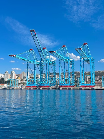 Dock cranes stand tall at a seaside port.
