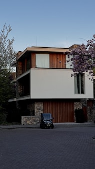 Modern home with a small car parked outside.