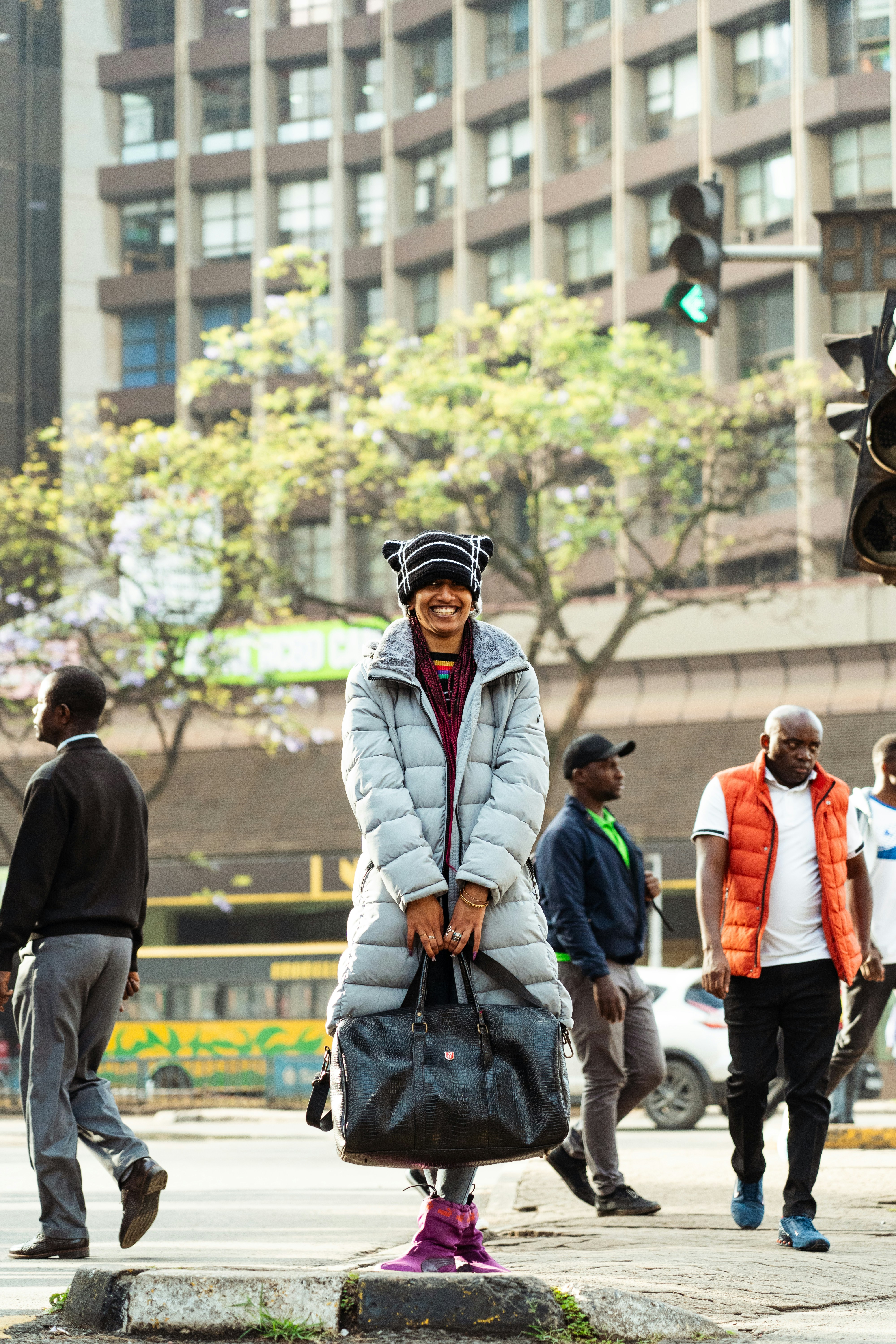 A woman smiles while walking through a city street.