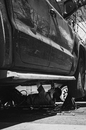 A mechanic works under a car.