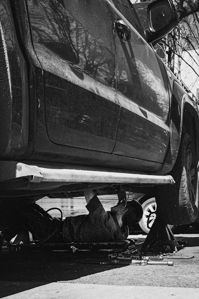 A mechanic works under a car.