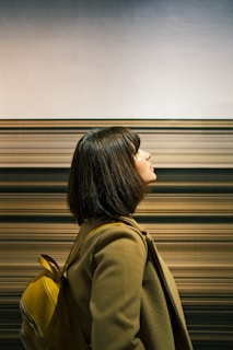 Woman admires abstract artwork in a gallery.