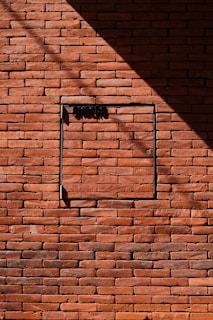 Brick wall with a dark shadow and door.