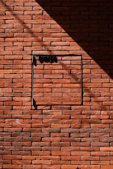 Brick wall with a dark shadow and door.