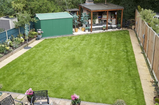 A well-maintained backyard features green grass and buildings.