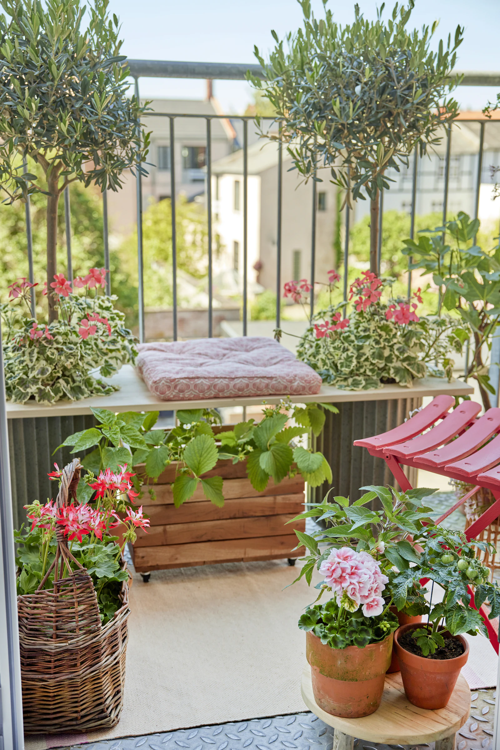 A balcony container garden filled with blooming potted plants