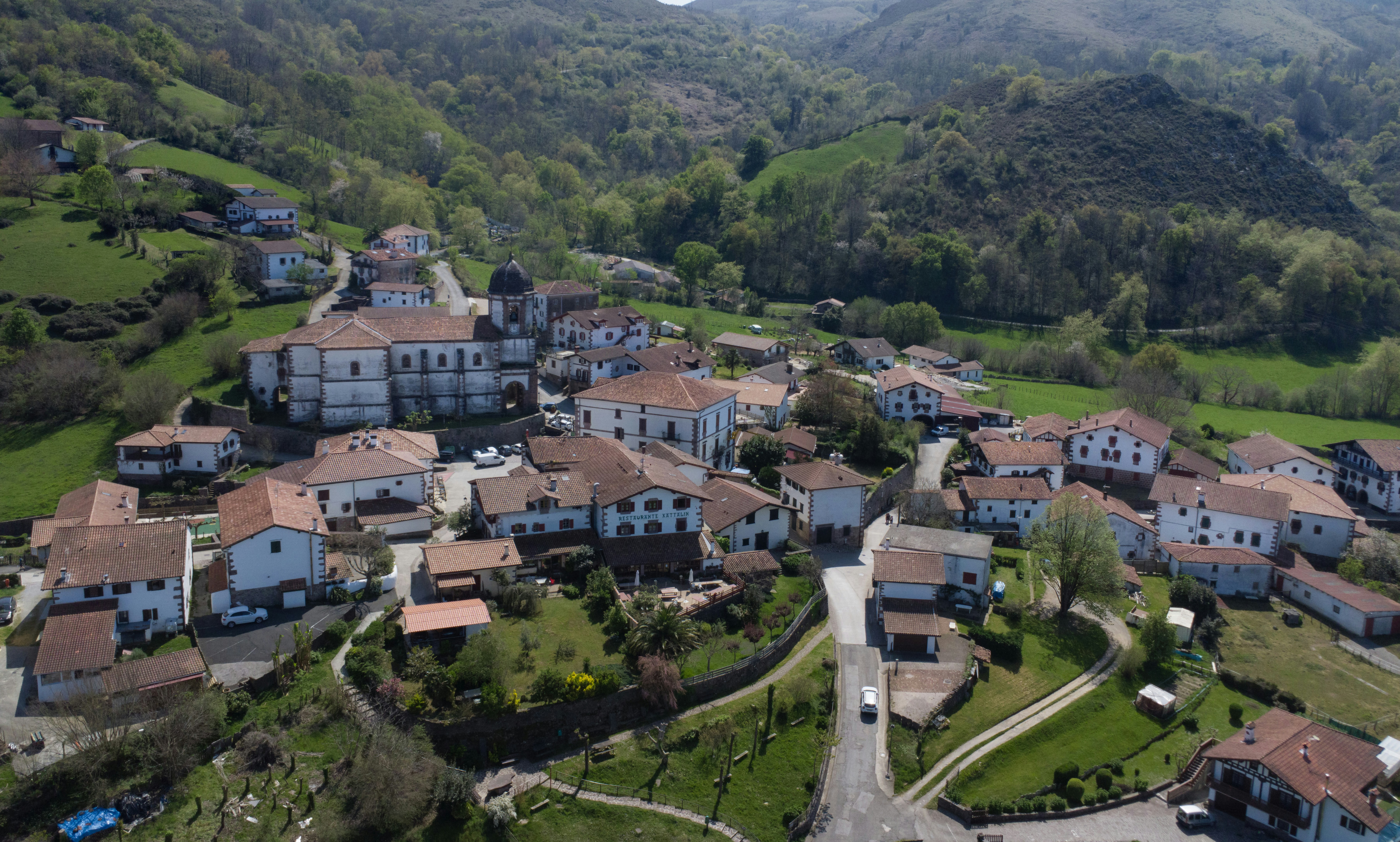 A picturesque village nestles amongst green hills.