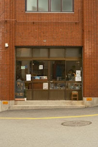 A brick building entrance with storefront and windows.
