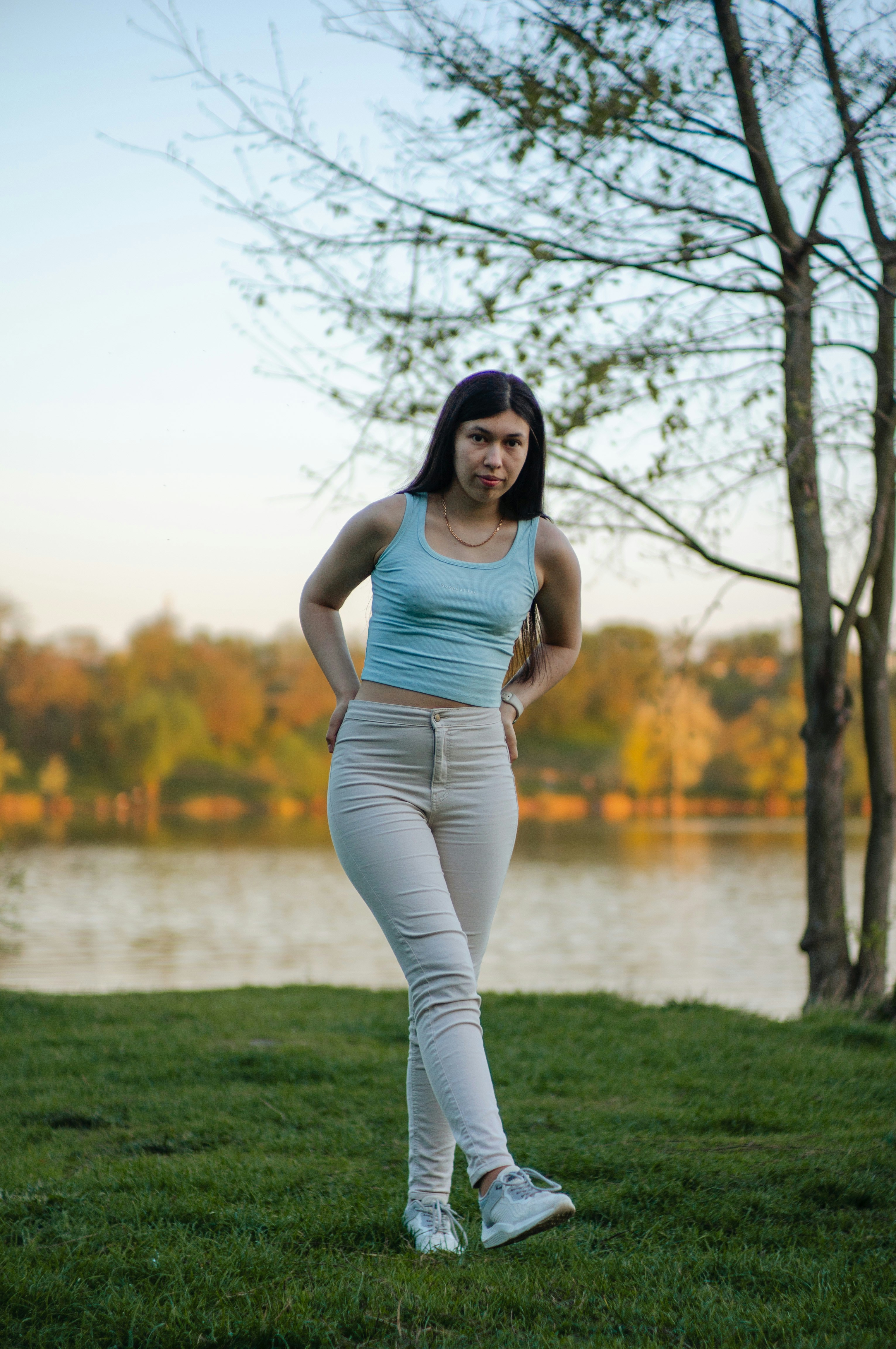 Eine junge Frau posiert an einem See.