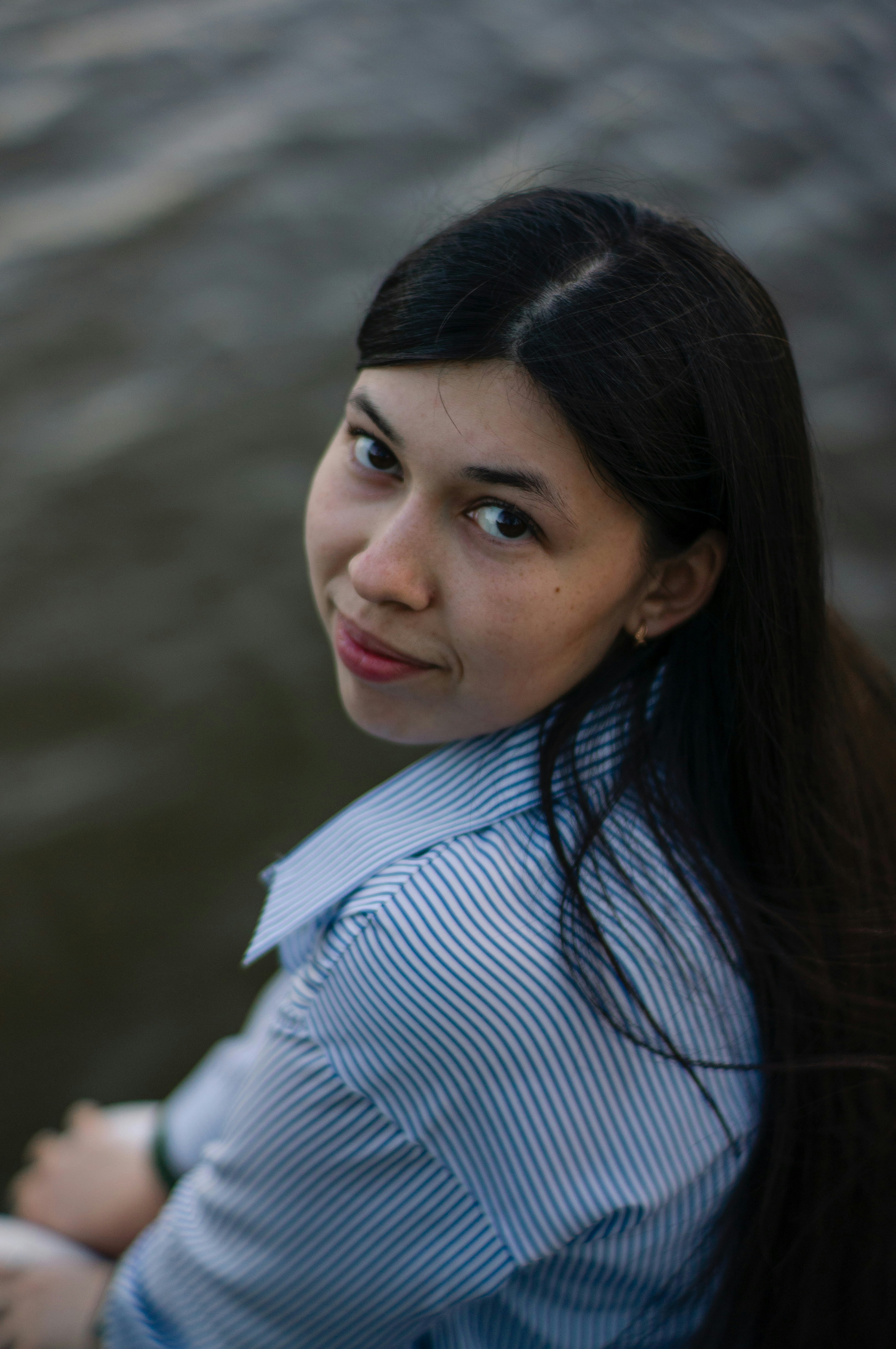 Eine Frau blickt über ihre Schulter in den Betrachter.