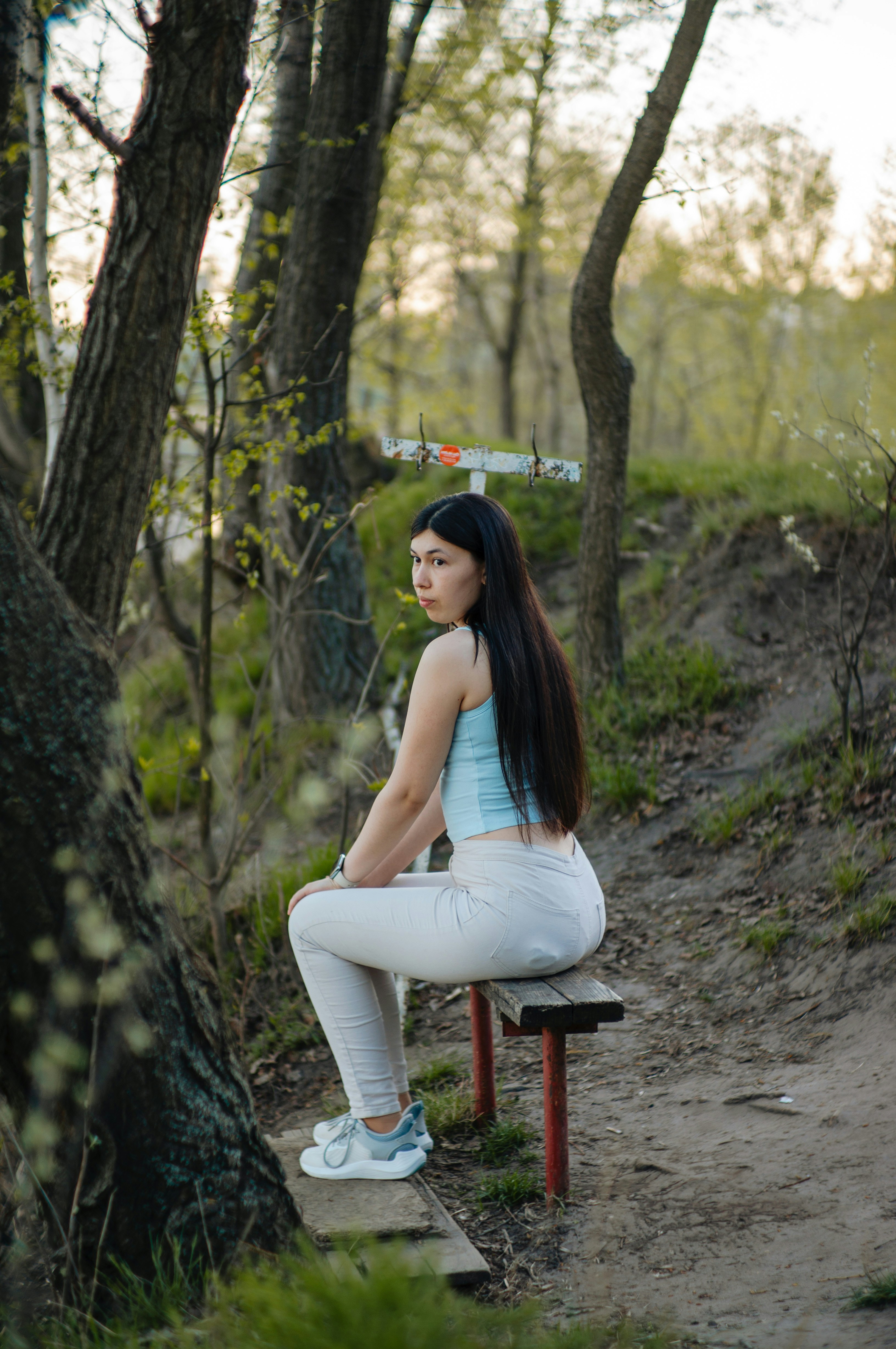 Eine Frau sitzt auf einer Bank in einem Park.